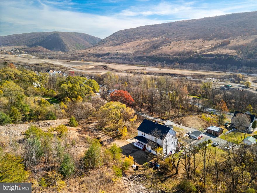 This FULLY REMODELED 5 bedroom, 2.5 bath twin offers sweeping views of the Appalachian Mountains and Trail and is ready for its new owners. BRAND NEW features include luxury vinyl plank flooring throughout the main and lower levels, fresh paint, new kitchen appliances and updated bathrooms. The lower level provides an extended-family suite with a private entrance, full 2nd kitchen, bedroom that can accommodate a twin sized bed, full bath, and laundry room. Outside, enjoy a large side patio, 3 covered porches, and parking for 8 vehicles. Additional updates include a new 200-amp electric service and roof. The neighboring corner lot is included in the purchase, expanding the total property size to approximately 0.387 acres. Note: The Borough is currently installing a new drainage system to manage mountain water runoff; the visible construction and piping around the streets are part of this project. Enjoy low taxes and a quick commute to all major roadways. Schedule today!