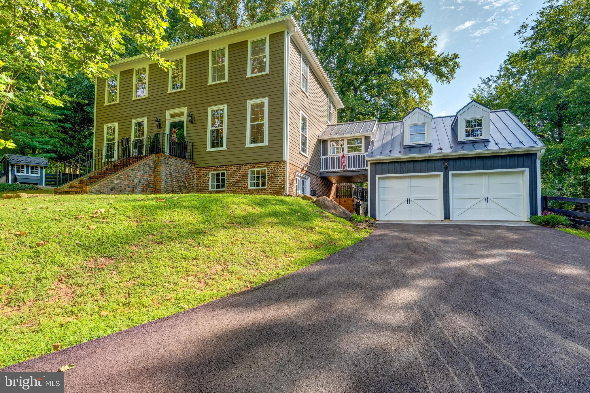 This stunning custom-built colonial is in immaculate condition and truly move-in ready, blending historic charm with modern conveniences. Nestled on a fully fenced 1.63-acre lot, the home is surrounded by mature trees, professional landscaping, and a tranquil English garden with fountain, creating a serene, park-like setting. The property also features a 10x20 hobby barn/shop with two stalls, a tack room, concrete patio, electricity, and seasonal water, a 10x12 shed with electricity, and a chicken coop—perfect for hobbyists, gardeners, or small livestock.
Thoughtfully curated antique details fill the home, including an antique banister, front door, and reclaimed architectural elements. Beautiful refinished Heart of Pine hardwood floors flow throughout, enhancing the timeless appeal. The oversized two-car garage, complete with a loft for additional storage, is conveniently connected to the home by a charming covered breezeway, and the property is further enhanced by a paved circular driveway.
Step inside through the antique front door into a warm and inviting foyer that sets the tone for the home’s character and charm. The main level offers a bright living room and an elegant formal dining room, both perfect for entertaining, as well as flexible space to suit your needs. Classic architectural details are found throughout, and refinished hardwood floors flow seamlessly across the entire main level.
The beautifully updated eat-in kitchen boasts all-new appliances and fixtures, a spacious custom-built cherry wood island with granite countertops, and plenty of room to gather. The kitchen flows seamlessly into the family room, which features an electric fireplace with mantle, custom built-ins, and French doors that lead to the backyard and patio, creating an ideal indoor-outdoor connection.
Upstairs, you’ll find four spacious bedrooms and two updated bathrooms. The primary suite features a double sink granite-topped vanity, updated lighting, a clawfoot soaking tub, a separate walk-in shower, and a walk-in closet. The additional bedrooms share an updated hall bath with double sinks and granite countertops, which connects conveniently to the upstairs laundry area for added functionality.
The finished lower level includes a versatile rec room or potential second primary suite, complete with a full bath and a kitchenette with a sink, dishwasher, granite countertops, refrigerator, cabinetry, and a separate counter area—perfect for meal prep, storage, or conversion into a home office or creative space.
Updates include: standing seam metal roof and gutter/downspout replacement with gutter guards (2025), refinished hardwood floors and new carpet on the bedroom level and lower level (2025), fresh interior and exterior paint (2025), GE Profile appliance upgrades including refrigerator, microwave, dishwasher, stovetop, washer and dryer (2025), asphalt driveway completely redone (2025), Generac 20kW whole-house generator (2018), HVAC system (2018), radon remediation system, water treatment system, Rinnai tankless water heater (2018).
