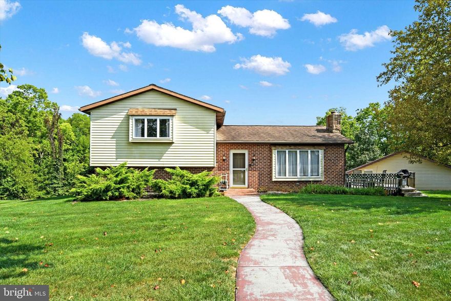Welcome home to this spacious split-level on a fantastic 1-acre lot in Lower Allen Township! The large living room boasts an efficient coal stove, the perfect spot on those cold winter nights. The kitchen is well-equipped with plenty of cabinet/storage space and flows into the dining room. Off the dining room is a convenient deck, perfect for entertaining. Upstairs are 3 bedrooms, the primary with built-ins, crown molding and convenient half bath. A full bathroom completes the 2nd level.  The lower level offers a large family room and is the perfect space for movie or game night! A 2nd composite decks is situated off of the family room and offers beautiful views of the sprawling backyard. Sip your morning coffee while watching the deer pass by. Located in the desirable High Meadow neighborhood, this home boasts 4 total garages with a lift, perfect for car enthusiasts. The detached 2 car garage is conveniently heated and air conditioned and provides a great workshop for all your hobbies. This 1-time owner home is a diamond in the rough and with a few minor aesthetic updates can really shine through! Located close to main roads, shopping and parks, this home is a joy to own!