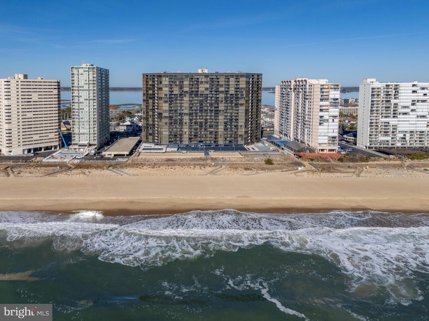Perched high on the 20th floor of the iconic Golden Sands Condominium, this direct oceanfront two-bedroom condo delivers breathtaking, floor-to-ceiling views of the Atlantic Ocean from the moment you step inside. The spacious primary suite offers sweeping ocean views and direct balcony access, creating a true retreat above the shoreline. Fall asleep each night to the rhythm of the waves and wake each morning to a spectacular sunrise over the ocean, all without leaving the comfort of your bed! The second bedroom captures beautiful views of Assawoman Bay, offering a peaceful contrast of sunrise and sunset vistas. A thoughtfully designed Jack-and-Jill layout provides each bedroom with its own private half bath, connected by a shared tub and shower, perfect for guests, family, or rental flexibility. The open-concept living area is designed for effortless coastal living, whether you're relaxing after a day at the beach, preparing meals, or entertaining with the ocean as your backdrop. Golden Sands is known for its exceptional resort-style amenities, including an expansive outdoor pool, sun-drenched pool deck, Tiki Bar beachside snack shack, top-floor indoor pool and fitness center with panoramic ocean and bay views, sauna, game room, sports courts, and on-site shops and dining. Whether you're searching for a weekend getaway, a high-demand investment property, or your own year-round oceanfront escape, this 20th floor residence offers the elevation, views, and amenities that make Golden Sands one of Ocean City's most sought-after oceanfront buildings.