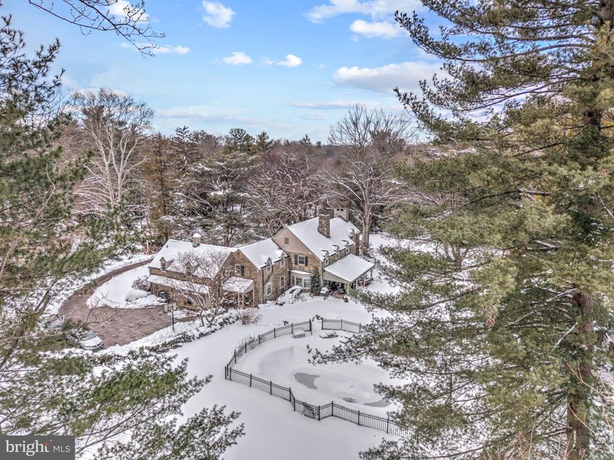 Tucked into the coveted North Side of Bryn Mawr, this distinguished residence offers a rare blend of architectural grace, refined comfort and an exceptional Main Line address. Set on two exquisitely landscaped acres, this historic stone estate offers four bedrooms and four-and-a-half baths, blending grand scale with intimate warmth.  A gracious foyer with original hardwood floors -refinished in 2016- sets the tone for the home's refined interior. The impressive step-down living room is among the Main Line's most elegant, featuring a gas fireplace, custom built-in shelving and lovely wall sconces that create a sophisticated yet welcoming ambiance. The sunlit formal dining room is designed for memorable entertaining, complete with built-in china closets, a crystal chandelier and French doors that open to a large covered porch overlooking the tranquil shade garden - an idyllic setting for al fresco dining and summer soirees! The richly appointed study showcases remarkable millwork, pocket doors, built-in bookcases, recessed lighting, a gun cabinet and a fireplace framed by exquisite hand-painted tiles adorned with birds - an artistic and architectural focal point.  At the heart of the home is a breathtaking custom kitchen built in 2015 by Paradise Custom Kitchens. Thoughtfully designed for both culinary excellence and every day living, it features abundant custom cabinetry, a Wolf gas range with a griddle and double ovens, a custom Sub-Zero  refrigerator, two Miele dishwashers (one specifically for fine china) , a warming drawer, a trash compactor and a custom built-in Miele coffee station. The expansive center island, topped with Esmeralda granite, comfortably seats five and offers integrated electrical outlets for convenience.  A dining area, currently being used as a sitting area, could easily accommodate a large dining table with chairs. A beautifully finished butler's pantry with marble countertop and illuminated cabinetry  enhances both function and form. A discreetly located powder room and an oversized 3-car garage complete the first level. Ascend the stunning staircase to the remarkable second level, illuminated by a spectacular chandelier that casts a warm, refined glow over the landing below. The primary suite is the epitome of elegance - a private sanctuary designed for rest and relaxation after a full day or work or leisure. A beautifully carpeted dressing area offers four generously sized closets, thoughtfully designed to accommodate an extensive wardrobe, handbags and shoes with ease. The spacious bedroom is filled with natural light from abundant windows, creating a serene atmosphere. The en-suite tiled bathroom is luxuriously appointed with an oversized soaking tub, double vanity and custom cabinetry. A delicate chandelier adds a final touch of sophistication to this lovely owner's retreat. Two additional large bedrooms are thoughtfully connected by a beautifully renovated Jack & Jill bath (2015), designed with a modern, spa-like aesthetic and quality custom finishes. The fourth bedroom offers exceptional versatility, featuring an en-suite bath, an adjoining sewing room and just beyond, a generously sized playroom and full bath. With convenient back stair access to the kitchen, this wing of the home lends itself beautifully to a variety of uses, including an au pair or in-law suite. The floored attic includes a huge cedar closet and abundant storage, while the partially finished basement is currently utilized as a gym, arts and craft room and  additional storage rooms/ areas, offering practical functionality to complement the home's elegant living spaces. The manicured gardens and elegant outdoor entertaining areas provide a serene space to relax and enjoy the resort-stlye pool. The thoughtfully designed chicken coop with 4 hens adds a touch of countryside sophistication! This is luxury living reimagined! The home  is being sold in "AS IS" condition.