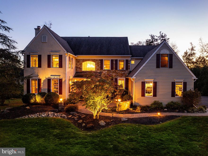 Tucked toward the end of a quiet street near the cul-de-sac in the sought-after Foxfield Reserve community, this beautifully appointed classic farmhouse offers over 6,000 square feet of thoughtfully designed living space on a picturesque .53-acre homesite. From the moment you step into the wide, recessed foyer, the home’s welcoming scale and tasteful neutral décor set the tone for comfortable everyday living and effortless entertaining. The heart of the home is the bright and airy gourmet kitchen, perfectly positioned beside the dramatic two-story family room with a floor-to-ceiling stone fireplace and soaring volume ceilings. Both spaces connect seamlessly to the oversized Trex deck, where the current owners have enjoyed countless evenings of al-fresco dining, gathering around the firepit, and relaxing under the stars. A beautifully designed home office with custom built-ins provides an ideal work-from-home retreat, while the living room with a second fireplace offers a warm, inviting space that flows easily into the dining area—creating an elegant yet comfortable setting for hosting family and friends. A formal powder room and laundry room complete the main level. Dual staircases provide convenient access to the second floor, with the front staircase offering a particularly dramatic introduction. Upstairs, the spacious owner’s suite serves as a true sanctuary with walk-in closets and a recently renovated spa-like bathroom finished in timeless style. An en-suite bedroom and two additional bedrooms connected by a shared adjoining bath complete this level. The walk-out finished lower level expands the home’s versatility with abundant daylight windows that keep the space bright and inviting. Currently configured with a home gym, recreation area, and wine cellar, the layout could easily accommodate a sixth bedroom or guest suite, thanks to the presence of a full bathroom. Life in Foxfield Reserve is as appealing as the home itself. The neighborhood features sidewalk-lined streets, mature trees, and direct access points to the Lower Gwynedd trail system, making it easy to enjoy the outdoors. The location is also uniquely convenient—students can walk to Wissahickon’s elementary, middle, and high schools, while nearby Springhouse Shopping Center offers everyday essentials and local favorites including Whole Foods, CVS, Arpeggio’s, boutique fitness studios, and neighborhood cafés. With a three-car garage, proximity to regional rail, and easy access to Routes 309, 202, and the PA Turnpike, this exceptional home combines space, style, and location in one of Lower Gwynedd’s most beloved communities.