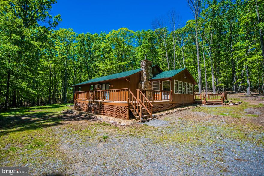 Beautiful 3.35 wooded lot with ranch style home. Featuring 3 bedrms, and 2 full bathrms, full kitchen w/ wood log bar, living rm w/ stone fireplace, master bedrm w/ master bathrm, 4 season sunroom, front and back decks, new Pergo flooring throughout, newly painted, new roof, large shed for your canoes and kayaks. Community park with  BBQ grills, picnic tables, bathrooms, and Cacapon River access.