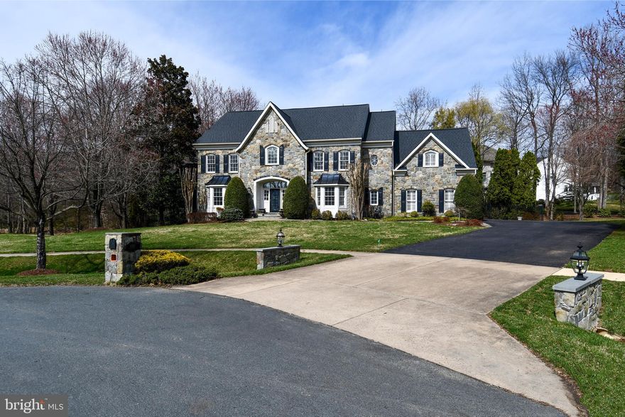 Welcome to 4007 Wintersweet Court in the sought-after Preserve at Smalls Nursery community in Rockville, MD. This impressive Craftmark Homes, Kenwood model offers 6 bedrooms, 5.5 bathrooms, approximately 7,938 square feet of living space on a .44-acre lot. From the moment you arrive, the home makes a stunning impression with Calvert stone walls on each side as you enter the driveway with lantern lights, custom stone mailbox, and front exterior lighting, highlighting the beautiful stone front, brick garage side, and vinyl siding exterior. The home has been freshly painted throughout.
Step inside to a welcoming foyer featuring a beautiful spiral staircase that leads into the heart of the home. The grand family room offers soaring ceilings and a striking stone gas fireplace, creating the perfect gathering space. The main level also includes a formal living room, elegant dining room, sunroom filled with natural light, and a private office with custom built-in shelving.
The gourmet kitchen is designed for both everyday living and entertaining, featuring a Viking gas cooktop, gorgeous custom hood, double Thermador wall ovens, warming drawer, built-in microwave, and a Sub-Zero refrigerator with custom wood panels matching the cabinetry. A large center island easily seats six stools, complemented by a separate table area for casual dining. The kitchen also includes a butler’s pantry with shelving and a wine refrigerator for added storage and entertaining convenience. Just off the kitchen is a winterized porch with heat and air conditioning, perfect for year-round enjoyment. The fully finished walk-out basement provides additional living space and features a dedicated wine cellar, along with plenty of room for recreation, guests, or a home gym. The owner’s suite is a true retreat, offering his and her closets and a private sitting room with custom built-ins and a charming window seat. The spa-like owner’s bath includes a separate soaking tub, spacious shower, and two separate sink areas. Outdoor living is just as inviting with a Trex deck and a beautiful flagstone patio with a built-in seating wall, perfect for relaxing or entertaining, all within a fully fenced backyard. Residents enjoy walking trails and a playground just steps away, with convenient access to ICC (MD-200), the Rockville Metro (approximately 6–7 miles away), shopping, dining, and parks.