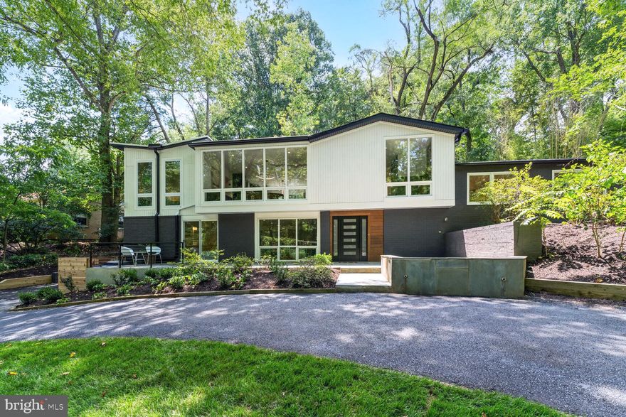 Absolutely one of a kind, this fully reimagined Hollin Hills mid-century modern masterpiece was originally designed by acclaimed architect Charles Goodman. The property has been meticulously expanded with an addition and thoughtful floor plan alterations to fit a modern lifestyle. It features five bedrooms, four full bathrooms, and three half bathrooms. 

The main entrance into the home is a large, welcoming entryway with a stylish terrazzo fireplace, storage, and guest coat closet. Continuing on this level, to the spacious family room with a wet bar and wine chiller, a private guest bedroom including a tranquil en-suite bathroom, and a generous walk-in closet. There is also a discreet owner's entryway from the side of the home that features a large coat closet, a built-in mudroom, and a stylish powder room. This level also includes a large laundry room with cabinets and counter space, and an extra storage room. 

On the next level, you'll find three bedrooms. Two of the bedrooms share a hall bathroom with a tub and dual vanity, while the third has an en-suite bathroom with a walk-in shower. Another half floor up, you enter the open floor plan living, kitchen, and dining space. The kitchen boasts modern flat-front cabinetry, a double-thick quartz waterfall island, and high-end JennAir stainless appliances. There is a large walk-in pantry with additional overhead dry goods storage. Floor-to-ceiling windows flank both sides of this wonderful open living/entertaining space, filling the area with light and giving the feeling of being nestled in the trees. There's a beautiful floor-to-ceiling ceramic fireplace, a dry bar with a drink cooler, and wine storage. An additional powder room off the kitchen completes this space. 

The large primary suite is set privately on the opposite side of the house from the other bedrooms. It includes two walk-in closets, a shoe storage closet, and an additional washer/dryer closet. The primary bathroom features a large wet room with a freestanding soaking tub, dual shower heads, a large dual vanity, and a water closet with a bidet-style toilet.

The front and rear of the property have expansive flagstone patios, perfect for socializing with neighbors strolling past or hosting a private outdoor party. 

There is an additional finished detached structure on the property that is perfect for a studio, office, or gym, creating a private space for working or meditation. 

This property offers incredible privacy, with forested areas to the front and rear of this oversized lot. The size of the land leaves endless possibilities for landscaping or adding a private pool. 

Everywhere you look, you will find high-end finishes and attention to detail, from the designer ceramics to the white oak floors. 

Hollin Hills is listed on both the National Historic Register and is one of Fairfax County's Historic Overlay Districts. It is a community born out of both unique architecture and its long history of community building. It is a world unto itself in a bustling city. The mature trees provide the setting for the 450 Goodman-designed mid-century modern homes. There are seven parks in the community, several of which offer great hiking trails. There are many charming and nostalgic annual events, from the Fourth of July Picnic with sack races and egg toss to Oktoberfest with kegs and brats. Living in Hollin Hills can truly provide a unique Americana experience. Enjoy all that this community offers, including access to Hollin Meadows Swim and Tennis Club, Hollin Hills Pool, Hollin Hills Pickleball and Tennis Club, and Sherwood Hall Library.