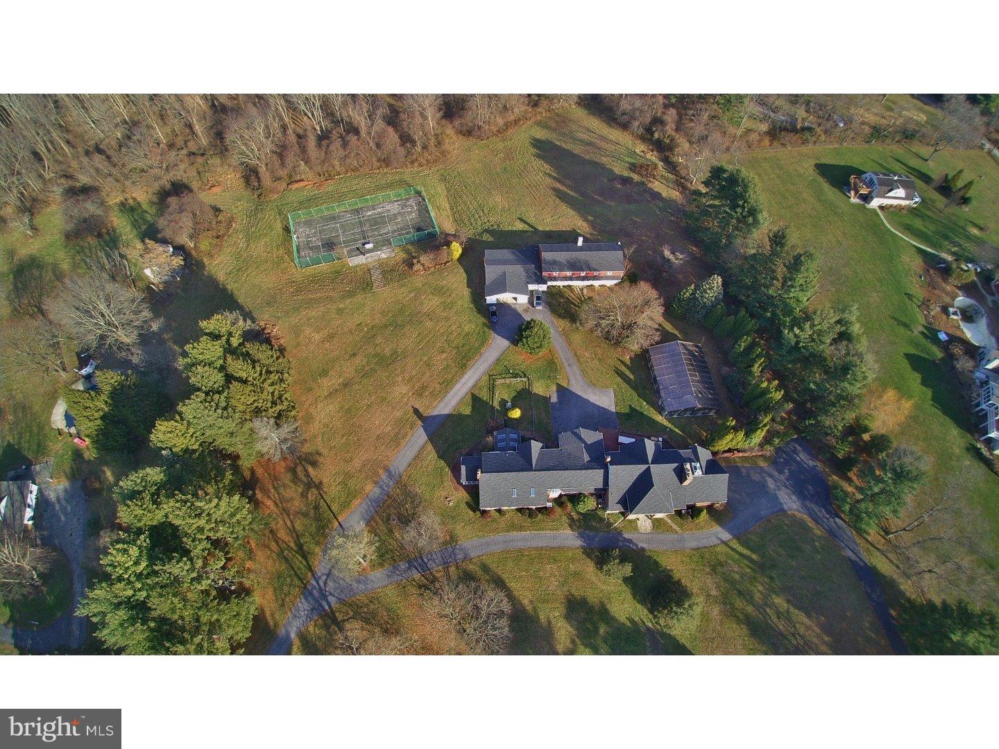 A very special opportunity to make a home in the elite community of Radnor Hunt. Horse country's most beautiful rolling green land, featuring a 16-stall barn converted to a four bed, two and a half bath guesthouse and nearly-new (2010) indoor/outdoor inground saltwater pool, and woodland stream. The barn is easily reverted back to its original use! Bring your imagination to this unique 7,800 square foot home to render its existing elements spectacular, with a grand entry which reveals the architectural interest found throughout this home: cathedral ceilings, arched entries, inset fireplaces, exposed beams, two staircases, a catwalk, and creatively placed skylights and greenhouse windows. The spacious entry hall welcomes guests with a dramatic curved brick wall and a built-in hearth to cozy up to. Also on the first floor, you'll find a formal dining room, kitchen, utility room, wood-paneled fireside study, and an inviting family room with stacked stone fireplace wall with built-in niches for firewood. A breezeway leads you outside to a brick patio and beyond to your extensive grounds and the custom-built indoor pool housed in a heated glass structure that keeps you warm in the cold but opens to the air in the summer weather. While outside, explore the woods or the converted barn with a stone fireplace and game room in the first floor, and apartment upstairs, charming with exposed beams and joists throughout, plus garage space for up to nine cars. Back inside, climb the curving staircase to the catwalk, leading to an artist's loft (or bedroom!) in one direction, and to the vast master suite in the other, complete with dressing room, enormous bath, bedroom, and huge walk-in closet. Access two more family bedrooms (one now a walk-in closet) and full baths from the second set of stairs. A full basement is ready for finishing, offering even more opportunity for entertaining, additional bedrooms, a home theatre, or anything else you desire. This one-of-a-kind eleven acre property is priced to sell to a lucky buyer with vision and a desire for peaceful living.
