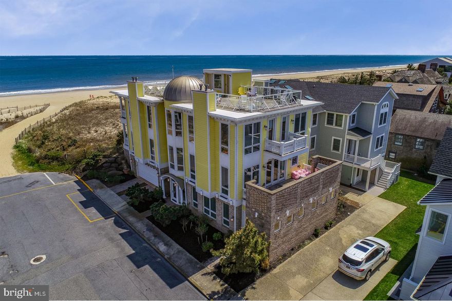 Oceanfront excellence! 4 Prospect Street is a rare opportunity to own a piece of Rehoboth Beach featuring unparalleled ocean and Silver Lake views.   Situated at the very tip of the southern end of the boardwalk, this distinctive home leaves nothing to be desired and could not be reproduced according to today's town codes!  A grand spiral staircase is the central focal point upon entry into the foyer of this magnificent home. The first level features 2 guest suites with private baths, laundry room, powder room and a rare 2-car garage. In addition, the back door leads into a mud room with additional laundry, 2 showers and a steam room perfect for after returning from a long day on the beach. As you enter the main level you will be greeted by beautiful views of the sandy beach and natural dunes leading to the ocean. The grand oceanfront living and dining rooms feature a stunning coffered ceiling and flanked with two gas fireplaces leading to a beautiful oceanfront covered porch. On the west wing of this level you will find an expansive gourmet kitchen with Liptus custom cabinetry, Viking, Bosch and Sub-Zero appliances and an enormous island ideal for entertaining. The kitchen is open to a family room complete with a gas fireplace, built-ins with media closet and wet bar including a beverage fridge and wine storage. This space opens to a charming courtyard surrounded by a beautiful brick wall ideal for outdoor grilling and dining. Continuing to the 3rd level, you will find a magnificent oceanfront master suite complete with sitting area, gas fireplace, private laundry, spa-like master bath with a jetted tub overlooking the ocean, tiled shower, custom walk-in closet and oceanfront balcony. Also, this level includes 2 more guest suites each with private baths and access to private balconies. In all, this distinctive floorplan boasts 5BR, 5BA, 3 half baths, approximately 5,300 SF of living space, hurricane shutters, an elevator to each level including the rooftop deck that was specially engineered to host 100+ people, a Vantage control lighting system, IPE decking and so much more.