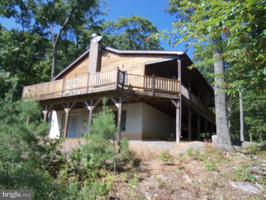 Lovely views from this well maintained cabin that shows like new.  Three large bedrooms with two large bathrooms.  Great room/dining and kitchen all open with sliding glass doors to the open deck.  Covered front porch gives the option of sitting outside during a rain storm.  Lower level is full walk-out basement to an area with space for seating, or fire pit. Has been a successful week-end rental.