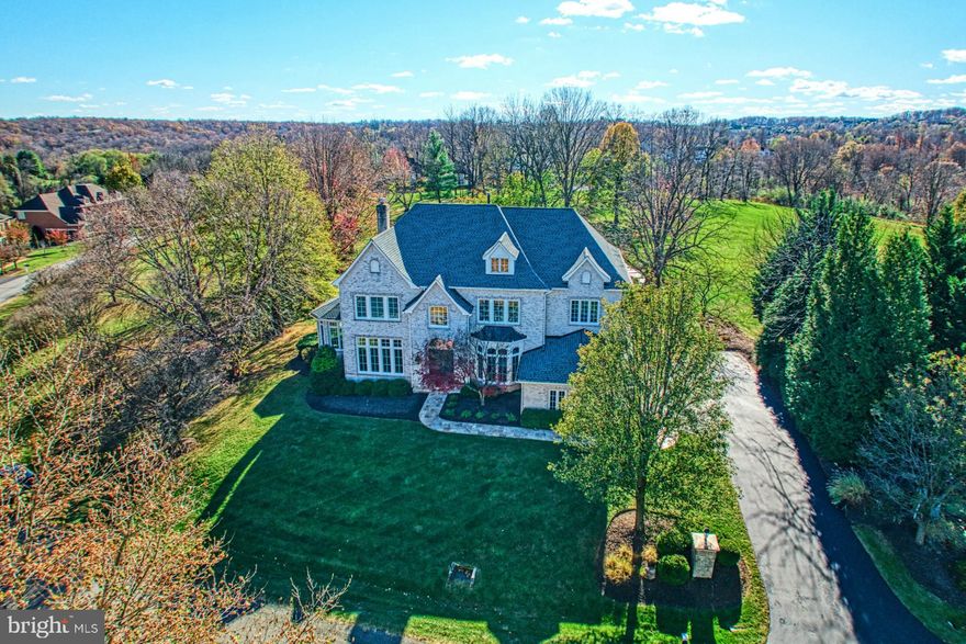 Nestled on 1.15 acres in prestigious Beacon Hill, this 7,015 square foot sanctuary offers modern sophistication surrounded by an exquisite outdoor oasis shaded by lushly landscaped grounds. While soothing cream-colored interiors capture and cast sunlight throughout the home, hardwood floors, high-end fixtures, endless windows, and a stunning centerpiece kitchen create a polished yet welcoming ambiance for entertaining and rest. While the chef’s kitchen invites culinary creativity with custom cabinetry, a sprawling granite island, and Miele appliances, your stunning outdoor haven hosts summer parties from under the spacious covered patio, with help from your built-in grill and stone-lined hardscapes. Stroll through the serene grounds for a moment of relaxation, or retreat to the home’s versatile lower level, featuring an expansive recreation room, kitchenette/bar, gym, and guest suite with full bath. In total, four airy bedrooms and four and a half tranquil baths ensure restful recovery. In total, four airy bedrooms and four and a half tranquil baths ensure restful recovery. In total, four airy bedrooms and four and a half tranquil baths care for recovery. In the sprawling primary suite, let the alluring wall of floor to ceiling windows cheer mornings with panoramic views. While on tour, visit the oversized garage, loft, and ask about comfort and sustainability additions including geothermal heating, recent roof replacement and more. A warmly modern escape, this meticulously updated Beacon Hill home captures both luxury and ease near to commuter routes, historic Leesburg, and famed wineries.