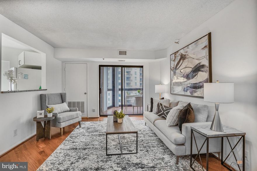 Experience the ultimate in convenience and style with this stunning 2-bedroom condo at The Altavista. Located directly atop the Ballston Metro, this home offers an unbeatable location with seamless access to everything Arlington has to offer.

Step inside to beautiful Brazilian Cherry hardwood floors, welcoming you into a spacious living area with a dedicated dining space. The kitchen is both stylish and functional, featuring granite countertops, crisp white cabinetry, and a pass-through window that connects to the living room—ideal for effortless entertaining.
Sliding glass doors lead to a private 11th-floor sunroom, offering stunning views over Ballston. This versatile space is perfect for a home office, reading nook, or relaxing retreat. The first bedroom enjoys direct access to the sunroom, plenty of closet space, and is conveniently located near the first full bath.

Down the hallway, hardwood floors continue into the primary suite, where you’ll find a large walk-in closet and an en-suite bath with a granite-topped vanity and tub/shower combo.
Additional perks include a dedicated storage unit just down the hall. While parking is not included, spaces are available for rent in the garage for $125 per month, with rental spots located on the top levels for added convenience.

The Altavista Condominium is one of Arlington’s most commuter-friendly buildings, sitting directly above Ballston Metro. The first seven floors are shared with the Hilton, providing a luxury hotel experience—perfect for out-of-town guests.

Skip the weather with an indoor walkway connecting you directly to Ballston Quarter Mall, Starbucks, and other shops. Building amenities include a 24-hour concierge, fitness center, community room and rentable parking spaces. With an A+ location and unmatched convenience, this is urban living at its finest!