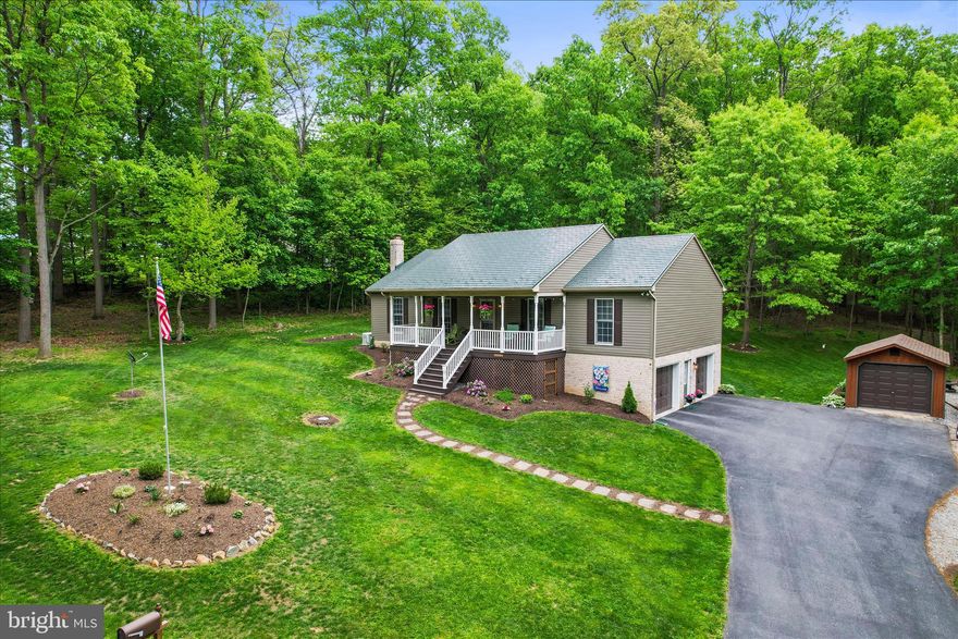 Discover the perfect blend of comfort, space, and peaceful surroundings in this beautifully maintained home offering 2,600 sq. ft. of living space on nearly an acre, nestled among serene woodlands where you can spot deer right from your yard. Relax on the inviting large front porch or entertain on the rear patio, already wired for your future hot tub. Inside, you’ll find a bright sunroom with heat and A/C featuring a brand-new patio door, an updated kitchen with granite countertops and soft-close cabinetry, and a spacious living room highlighted by a striking stone and barnwood accent wall. Laminate flooring flows throughout the home, which includes three bedrooms and three fully updated baths. The owner’s suite is a true retreat with a bay window, two walk-in closets, and a private bath showcasing a custom shower and double vanity. The lower level offers a cozy family room with a wood stove set on a brick hearth, plus an additional full bath—perfect for guests or extended living. Additional features include main-level laundry, a spotless finished garage with an epoxy floor, a durable metal roof designed to resemble shingles, propane heat, a tankless hot water heater, a whole house generator and a new outdoor A/C unit installed in 2024. New 12' x 16 Shed installed in 2022.   Black top parking for up to 8 cars plus there's even a stone pad to park a trailer.  A prime Southern Pennsylvania location ideal for Maryland commuters with easy access to Rt. 83, this home truly has it all.