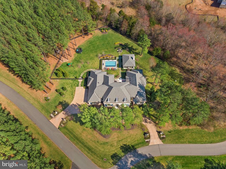 Welcome to your dream home! A custom French-style estate situated on one of the most private lots in the luxurious gated golf community of Creighton Farms. This exquisite property offers a grand entrance with soaring ceilings, marble flooring, impeccable woodwork and massive chandelier. The spacious living room offers a stunning fireplace, architectural niches and a wall of windows overlooking the lush landscaped grounds. Right off the family room is the gourmet kitchen featuring high-end appliances including Viking range, two Sub-Zero refrigerators, two dishwashers and granite counter tops. Recent renovations (2022) include opening the wall between the kitchen and living room providing a more open concept style. Enjoy breakfast in the morning room or relax in the nicely appointed family room with wood beamed ceilings, separate wet bar and French doors leading to the patio and backyard entertainment area. Unwind in the luxurious owners suite encompassing a sitting area with fireplace, and spa-like ensuite bathroom complete with a soaking tub and steam shower. Two spacious designer closets round out this magnificent space. The basement boasts a variety of charming features making it perfect for both entertaining guests or enjoying a night in. Choose from the bourbon tasting room, where you can sample a wide selection of the world's finest bourbons; the craft room, where you can unleash your inner artist; or the full bar, which provides the perfect setting to unwind after a long day. For those who love a good game of pool, the billiard room is sure to be a hit, featuring plenty of space to move around. There is also a 5th bedroom with an ensuite full bathroom. Whether you're looking for a quiet night in or planning a big gathering, this stunning basement has everything you need to create lasting memories with friends and family. The stunning backyard oasis is the perfect spot to entertain. The sparkling Lewis Aquatech pool beckons on hot summer days, while the pavilion provides shade for outdoor dining or lounging. A cozy fireplace invites cooler weather get-togethers, and a built-in BBQ makes outdoor entertaining easy and enjoyable. Surrounded by lush landscaping and manicured lawns, this backyard is a true haven for relaxation and fun. This stunning French-style estate in the prestigious Creighton Farms offers resort-style living with the amenities of a country club including an 18-hole Jack Nicklaus course, new golf facility with simulators, tennis courts, fitness center & pool. The clubhouse offers a full menu, hotel style rooms for members and their guests plus much more. Start living your best life today!