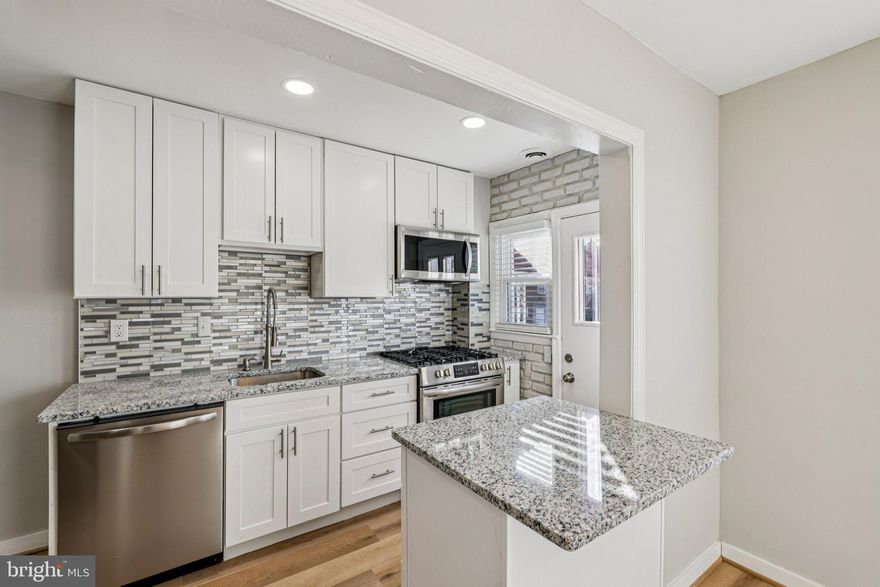 Fully Renovated 4BR/2BA Brick Rowhome! This updated and upgraded home features a modern kitchen with granite countertops and an island, hardwood floors, and a fully finished basement with a private 4th bedroom and full bath. The rear basement entrance leads to a level, fenced-in backyard—perfect for entertaining. Relax on the covered front porch or enjoy the comfort of central A/C. Quiet neighborhood location with easy access to commuter routes and transit. ROOF (less than 3 years old), Water Heater replaced in 2024, HVAC (less than 5 years), Kitchen renovated in 2025, and fireplace insert installed in 2025. Move-in ready and priced to sell!  Select photos for this listing have been virtually staged.