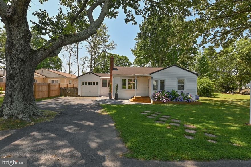 Welcome home to this cozy well maintained cottage located in the  gated, waterfront community in Columbia Beach.  Nestled in this serene neighborhood, this home offers a perfect blend of comfort, style and relaxation. As you step inside the home you are welcomed by this quaint mudroom that was recently updated with shiplap and new flooring. A perfect place to drop your shoes before you open the door to this beautiful home. As you walk in you notice the recently refinished floors that exude warmth and character throughout the home, creating a timeless appeal and seamless flow between rooms.  You will love the recently serviced pellet stove on those cooler nights that adds warmth and ambiance. Owners have freshly painted this entire home as well as updated all lighting. The two bedrooms in this home are spacious with ample closet space.  The bathroom was recently renovated ( 2023) with new flooring/ vanity and lighting.  The galley kitchen has been updated with stainless steel appliances and has granite countertops as well as a NEW dishwasher ( 2023), NEW stove and Microwave ( 2026)
As you walk through the French doors to the dining room you begin to see the real show stopper, the four season room and the amazing backyard.  The backyard is completely fenced with two freshly painted sheds and plenty of space for privacy, peace and relaxation. The owners just replaced the washer and dryer ( 2023). This home is steps away from the bay.  The community offers a fishing pier, kayak drop, a playground and small boat ramp.  You will feel like you are always on vacation in this adorable cozy cottage.  Home is conveniently located 30 minutes from Annapolis. Welcome home! NEW hot water Heater (2026)