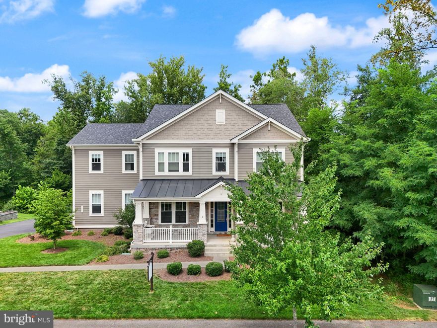 Big & Beautiful in Willowsford! Easy Flex to 8 Bedrooms, >6,000 Sq Ft, 3 Car Side-Load Garage, Private Owner's Suite Balcony, Screened-In Porch, Covered Front Porch, Gourmet Kitchen**Wolf Range**Sub Zero Fridge**,Coffered Ceilings, Built-In Speakers, In-Ground Sprinkler System, Main Level Full Bathroom, Protected Acreage Of Trees On  Side And Behind Property, Lightridge High School, Willard Middle School
Step into timeless design and modern luxury in this refined craftsman, nestled in the heart of The Grove at Willowsford. Built in 2016, this residence blends artisan-level finishes with comfort-driven design, offering 5 bedrooms, 5 bathrooms, and 6288 square feet of inspired living space. Set on a quiet street framed by mature trees, the home’s crisp HardiePlank facade and stone foundation invite you onto a full-length covered porch—a perfect perch for morning coffee or evening chats. Inside, solid hickory floors lead you through an open, sunlit main level that pairs intentional spaces with warm, livable flow. A dedicated office and formal dining room flank the foyer, while the heart of the home—an expansive great room, sunroom, and chef’s kitchen—offers the ideal layout for both everyday life and elevated entertaining. The kitchen is a showstopper: a Sub-Zero fridge, dual-fuel Wolf range, oversized granite island, and artisan tile backsplash create a space where form meets function. Upstairs, the primary suite is a true sanctuary—featuring a lounge with built-in coffee bar, mini fridge, private covered balcony, and a spa-like bath with freestanding tub, frameless glass shower, and dual quartz-topped vanities. Three additional bedrooms, two full baths, a loft retreat, and a laundry room with quartz counters and storage cabinetry complete the upper level. The walkout basement expands your options, with a spacious recreation room, guest suite, full bath, and a flexible bonus room perfect for a gym, media lounge, or second office. Outdoors, your private escape awaits. A 20x16 screened porch with exposed beams and stone wall provides an unforgettable space for dining and entertaining. A 10x16 deck and dual paver patios—including a 16-foot circular fire pit lounge—extend the experience, creating a backyard retreat perfect for gatherings both lively and laid-back. Every detail has been thoughtfully curated, every space intentionally designed. All that’s missing is you.  ** Willowsford HOA Conservancy fee : Buyer responsible for .25% of sales price + capital contribution at settlement