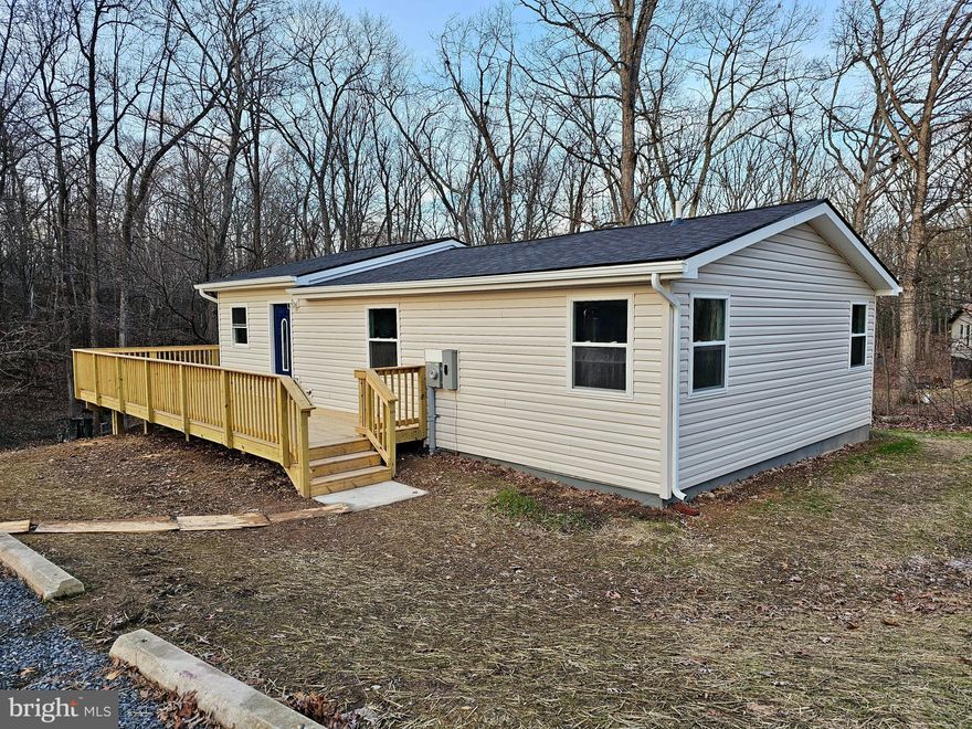 Brand new from top to bottom...inside and out...this could be the home you've been searching for! Sitting on just over 1.5 tree-lined acres, this little piece of paradise is the ideal setting for anyone wanting to be "away from it all" yet still an easy drive to anything they may need. Step inside where you are greeted by the open living area that features vaulted ceilings, a kitchen with all stainless steel appliances, plenty of space for a dining room table, and a family room area. Down the hallway, you'll find the Primary Bedroom with a private bathroom and 2 closets. Two additional bedrooms, a full bathroom, and a laundry area finish off the main level. Down the steps, there is an unfinished basement that can be used for storage or easily finished for additional living space. The wraparound deck gives you ample space for entertaining, nature watching, relaxing, grilling, and much more! From siding to flooring, appliances to paint, roof to HVAC...you'll swear you've stepped into a newly built home! An easy drive to Hedgesville, Martinsburg, Berkeley Springs, and MD! Schedule your showing TODAY before someone else claims this gem!!