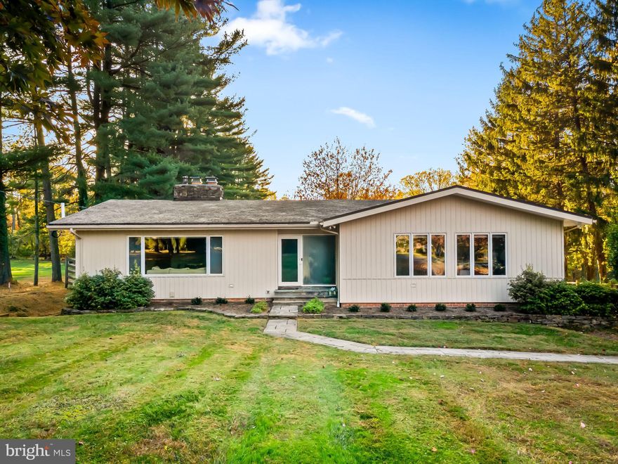 Set along the coveted Falls Road corridor on a quiet, tree-lined street, this mid-century modern ranch with guest cottage and in-ground pool sits on a stunning property surrounded by mature trees and exceptional privacy. A long, graceful driveway creates a true sense of arrival and hints at the beauty that unfolds inside and out. The location is one of the area’s finest, offering effortless access to both 83 and 695 for commuting, as well as the shops and dining of Hunt Valley and Greenspring Station.

Inside, the home blends classic mid-century architecture with beautifully considered updates. The living and dining rooms share a striking two-sided stone fireplace that anchors the space with warmth and sophistication. Newly installed luxury vinyl flooring complements the refinished hardwoods, and expansive windows frame serene views of the grounds.

The kitchen has been thoughtfully refreshed to honor the home’s original style. High-end mid-century cabinetry remains in place and pairs seamlessly with granite counters and stainless appliances. Both upper-level baths have been renovated and expanded, and the primary bedroom includes a well-designed owner’s closet. Two additional bedrooms on this level are bright, spacious and inviting.

Outdoor living is exceptional. Sliders from the breakfast area and dining room open to an upper-level deck with sweeping views of the property. It is an ideal setting for morning coffee, al fresco dining or evening sunsets. The lower terrace, garden pathways, fire pit area and the in-ground chlorine pool offer multiple places to unwind and enjoy the beauty of the fully fenced rear grounds.

The detached two-level garage is one of the most exciting features of the property. Along with parking, workshop and storage space, it includes a private one-bedroom guest or pool cottage that elevates the home’s versatility. With a high-end kitchen, full bath and independent heating and cooling systems, this space is perfect for in-laws, guests or extended stays and offers a rare level of comfort and independence.

The lower level of the main home provides even more flexibility with a spacious fourth bedroom, a half bath, a family room with a fireplace, a mid-century modern bar and a generous laundry and storage area. This level opens to the rear terrace and connects directly to the attached two-car garage.

With updated windows and doors, a gravel roof true to the home’s architectural style, new AC installed in 2021 and extensive renovations completed between 2021 and 2022 throughout the home, patios, fire pit and guest cottage, this property delivers a refined and modern living experience on a truly exceptional piece of land.