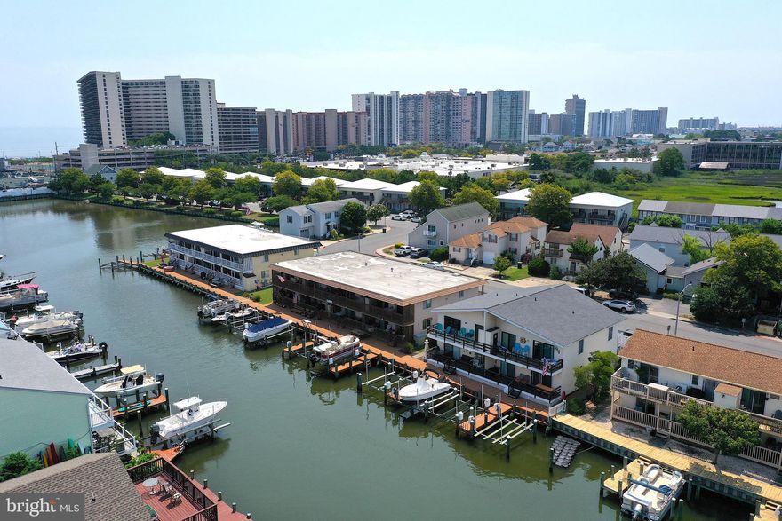 Well-maintained and nicely updated waterfront condo in Ocean City, Maryland with a deeded boat slip and power boat lift.  This condo offers two bedrooms, two full-bathrooms and an open living area.  The living area features a comfortably furnished living room and a fully-equipped kitchen with a convenient large center-island.  The kitchen has been updated with designer wood cabinets, solid-surface countertops and stainless-steel appliances.  There is a large, private balcony that spans the full width of the condo located off of the living area and master bedroom.  This is a great place to relax and unwind after a long day on the beach or out on the water.  The waterfront master bedroom features balcony access and a renovated ensuite full-bathroom.  The guest bedroom is generously sized and located in the rear of the condo for additional privacy.  Both bedrooms and the utility room feature custom storage solutions.  The second full-bathroom is centrally located and easily accessible from throughout the condo.  The condo’s utility room offers additional storage and a full-size washer and dryer.  The condo conveys with a boat slip and power boat lift that make boating easy and provide quick access out to the open bay.  The building’s wider canal provides a more open setting than other waterfront condos and plenty of space for docking and boat maneuverability.  Building amenities include onsite parking and a waterfront boardwalk.  The beach, shopping, restaurants and more are all within walking distance.  This condo conveys fully-furnished and equipped for turnkey enjoyment.   Ready to live the waterfront lifestyle in Ocean City?  Schedule your private showing today.