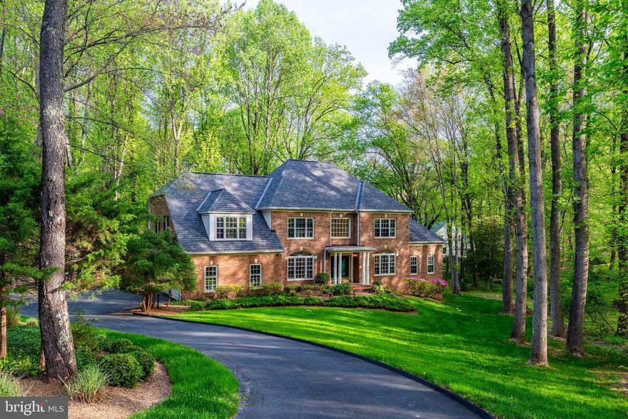 This elegant estate offers over 7,000 square feet of meticulously maintained living space on a private, wooded
2.08-acre corner lot in one of Great Falls’ premier neighborhoods. With more than $230,000 in thoughtful
upgrades—including a 50-year roof, dual well tanks, brand-new hardwood floors, Lennox Elite HVACs, premium
stainless-steel appliances, and a screened porch—this refined residence is move-in ready and designed to
impress.
From the grand two-story foyer, sunlight spills across new oak floors beneath a sweeping butterfly staircase.
Arched windows and intricate millwork adorn the formal living and dining rooms, while the layout flows seamlessly
into a sunroom with 10-foot ceilings and stunning views of surrounding wildlife. The gourmet kitchen boasts granite
countertops, white cabinetry, a downdraft gas cooktop, and new stainless appliances. Nearby, a spacious
mudroom, butler’s pantry, and private laundry room with a secondary refrigerator offer added convenience.
The soaring two-story family room features a dramatic brick fireplace, Palladian windows, and serene backyard
views. Outdoor living is enhanced by a screened porch and decking beside a gentle brook. Upstairs, brand-new Hardwood continues throughout. The private primary suite includes a sitting area, spa bath with Jacuzzi tub, separate shower, dual vanities, dressing area, and walk-in closet. Three additional bedrooms enjoy generous proportions and access to well-appointed bathrooms.
The finished walkout lower level includes a bedroom with dual closets, a full bath, an expansive recreation and game room, and large storage areas (potential for adding more living space)—perfect for entertaining or
Multigenerational living.
Community & Location Perks
Nestled amid lush landscaping and mature trees. The property is minutes away from Great Falls Park, Riverbend
Park, and Great Falls Village Centre, which offers charming coffee shops, restaurants, salons, farmers’ markets,
and more.
Top-Rated Schools
Zoned for Fairfax County’s finest schools: Great Falls ES, Cooper MS, and Langley HS.

Notable improvements include: a 50-year roof and gutters (2018), new dual well tanks with water test
passed (2025), septic system inspection passed (2025), hardwood floors (2024-2025), stainless steel
appliances (2024), a downdraft cooktop vent (2025), and a screened porch (2014).