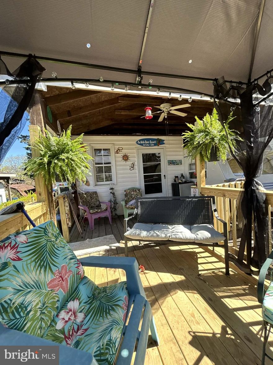 Welcome to Block 11 Lot 14 Hot Springs Ave on SEWER in Riverbends Rv Campground. Riverbend is 400 Acres of SEASONAL recreational campground full of amenities located on the Potomac River in Falling Waters, Wv. OPEN APRIL 1 - NOVEMBER 1 - This is a fun & entertaining community, yet relaxing. Financing Could be available. They require a minimum of 25% down of purchase price or appraised value.

This lot is move in ready for your 3 seasons of enjoyment! Making memories with friends and or family there is plenty of sleeping room here! Featuring a Primary suite room built on with a full-size bed, Full standard bathroom, futon, A/C, Fireplace, and more! Attached and under a roof sits a 2024 Wildwood camper with king size bed, two large bunk beds, sleeping 8 people.  This camper is equipped with and instant hot water in the camper and the primary bathroom has its own hot water heater. Outside you'll find newly constructed decks, with a gazebo, fencing and a small yard for the young ones or pets. The covered porch also has electric and a ceiling fan to keep that air flowing all summer. Conveying with this property is all the Patio furniture, one gas grill, mini fridge, tv and hanging fireplace. The Shed does not convey and will be moved leaving 3 parking spots.
Call today for your personal tour. Approx. 10 miles of Deep water on the Potomac River access for boating, fishing & swimming. Yearly membership ($1,987) plus a $200 initiation fee for new owners, includes water, sewer, electric, trash and the park amenities such as 3 pools, putt putt course, Horseshoe club, Boat club, Poker runs, Trick or Treat, Christmas in July, live bands, basketball court, tennis court, fireworks, car show, Church, restaurant, bar, convenience store (Great food), playground, volleyball, ball field and much much more. Bring your golf carts, water toys and come enjoy life!

For an additional $600 all the Beach theme decor can stay.