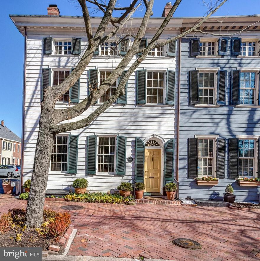 Exquisite 1808 Federal style townhome located in the heart of Old Town Alexandria!  With four upper-level bedrooms, 2 full and 2 half renovated baths and surprisingly ample storage, this picture-perfect home is a treat for the senses.   It is no surprise that this special home has been featured in numerous publications including Southern Living magazine and The Cottage Journal.  The iconic yellow front door greets you and upon entering the foyer, you can feel the grandness of the home with original wood floors and moldings, 10’ ceilings, and a gorgeous staircase. The expansive front parlor is adorned with natural light from 5 windows on three sides of the room, a beautiful wood-burning fireplace, and 2 sets of double doors that can be closed to create an intimate space.  The large dining room can accommodate a table for 10-12 guests and features a bay with French doors that leads to the side garden. The lovely kitchen features a Wolfe range, farmhouse sink with Water Works faucet, brick radiant heated floors, a door leading to the brick-walled back patio, and a conveniently located ½ bath.  Ascending the stairs to the second level the spacious primary bedroom is its own retreat with a wood-burning fireplace, a sitting area and a masterfully designed en suite bath with Water Works fixtures, heated floors, hidden storage, and chic finishes.  On this level you will also find a delightful library or bedroom with book-in bookcases, ½ bath with unique finishes, and a magnificent walk-in closet and laundry center.  The third floor features 2 additional elegant bedrooms, a newly remodeled full bath with heated floors, and a walk-in storage room.  Located on a charming block known as “Brockett’s Row”, this historic gem is just steps to the shops and restaurants on King Street, a few blocks to the Potomac River and Mt. Vernon Trail, and has easy access to Reagan National Airport, Metro, Amazon HQ2, and major commuter routes.