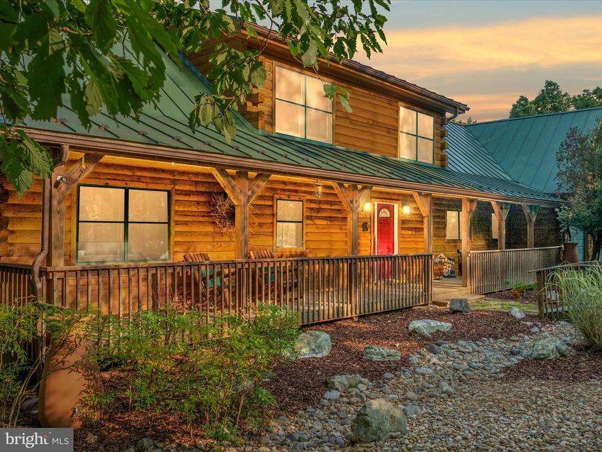 Nestled amidst 10 breathtaking acres of lush woodland, this stunning log cabin combines rustic charm with modern luxury. Crafted from pine logs and featuring gorgeous maple hardwood floors, the home greets you with soaring 30-foot ceilings and massive windows that frame picturesque views. The heart of the home is the expansive great room, centered around a striking solid rock wood-burning fireplace. The gourmet kitchen boasts granite countertops, stainless steel appliances, and seamlessly connects to a dining area with beautiful natural vistas. The primary bedroom is a serene retreat with an en suite bath and direct access to a wrap-around back deck, perfect for taking in the scenery. Outside, fresh landscaping and a spacious front porch invite relaxation, while the oversized two-car garage provides for extra room and attic access, offering potential for future expansion or ample storage. The fully finished basement features a cozy wood-burning stove, an additional bedroom, full bath, and access to a back patio, with a hot tub hookup already in place. There's also a partially unfinished space previously used as a studio, offering endless possibilities for customization. Upstairs, a spacious loft overlooks the grand living area, along with two more bedrooms and attic access. This property is outfitted with modern conveniences, including a 5-camera Lorex security system, an owned generator, Anderson doors, a woodshed/tool shed, and a partially fenced backyard. With river frontage along the Cacapon River, you can clear a path or trim a few trees for even more incredible views and water access. Located just 2 hours from DC and close to Capon Bridge and Winchester, this cabin is perfect for year-round living or as a second home getaway. It's not often that such a stunning retreat becomes available. Built and owned by one owner and meticulously maintained throughout the years. Schedule your showing today!