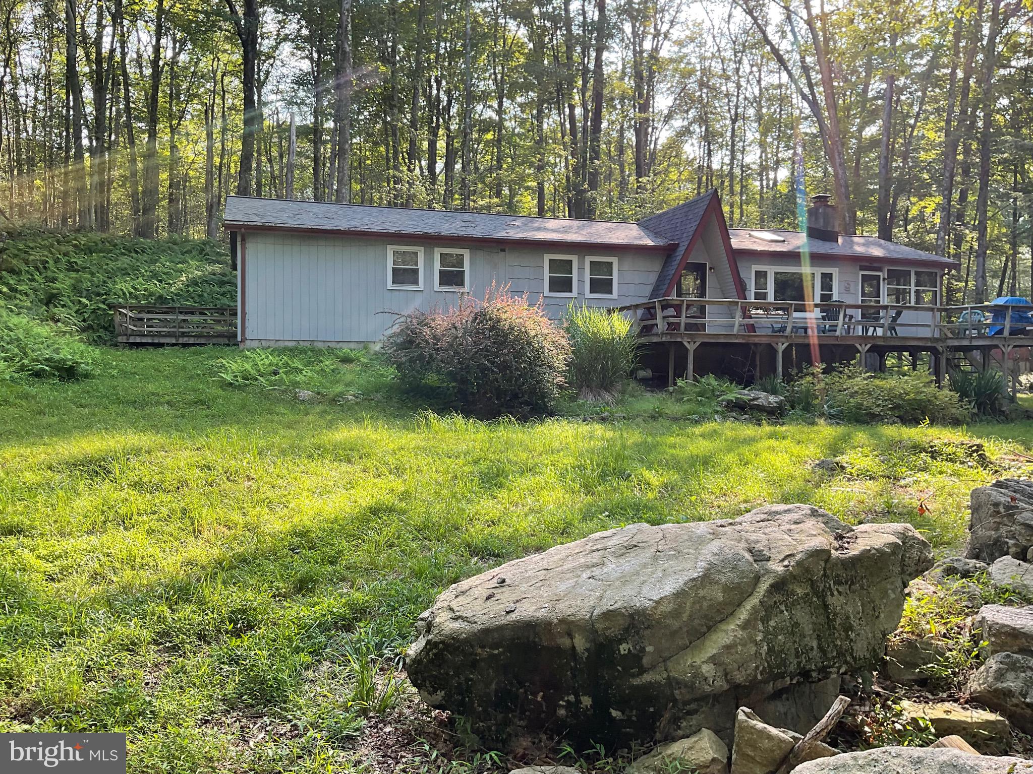 OVER 1 ACRE ON 3 LOTS; ONE SET OF DUES AND TAXES. Walk to sandy beach, playground, Beach 1, fishing, swimming, Boat launch, boat storage, bathrooms and lodge with year round activities. Home completely renovated with 3 bedrooms 2 full baths, laundry room, 3 season room, large front deck to enjoy nature and BBQ. Neutral colors throughout, stone fireplace in living room, with pellet stove insert. Ceiling fans in all rooms, plus granite in kitchen and laminated flooring. Would be a great rental property or getaway for your family.