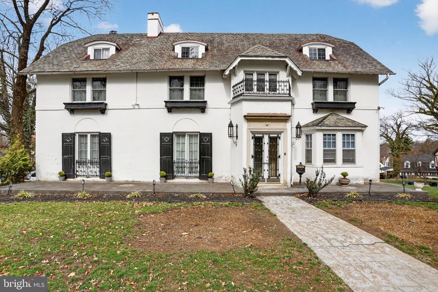 Welcome to 8148 High School Road—an exceptional six-bedroom, five-bath grand Colonial in the heart of Elkins Park, blending timeless character with modern updates throughout. Beautiful architectural details, including intricate millwork and bay windows, fill the home with warmth and natural light. The gracious living room flows into a spacious family room with a striking two-sided fireplace, perfect for both everyday living and entertaining. A formal dining room connects to an updated kitchen featuring granite countertops, stainless steel appliances, and a bright breakfast area. A dedicated home office adds convenience for remote work, while the expansive primary suite offers a beautifully updated bath and a stunning walk-in closet. Additional bedrooms provide ample space and flexibility across all levels. Enjoy outdoor living with a private in-ground pool, patio, and entertaining space, plus a detached two-car garage with potential for a studio or additional living area. A rare opportunity to own a character-filled Colonial with modern comforts in a highly desirable location.