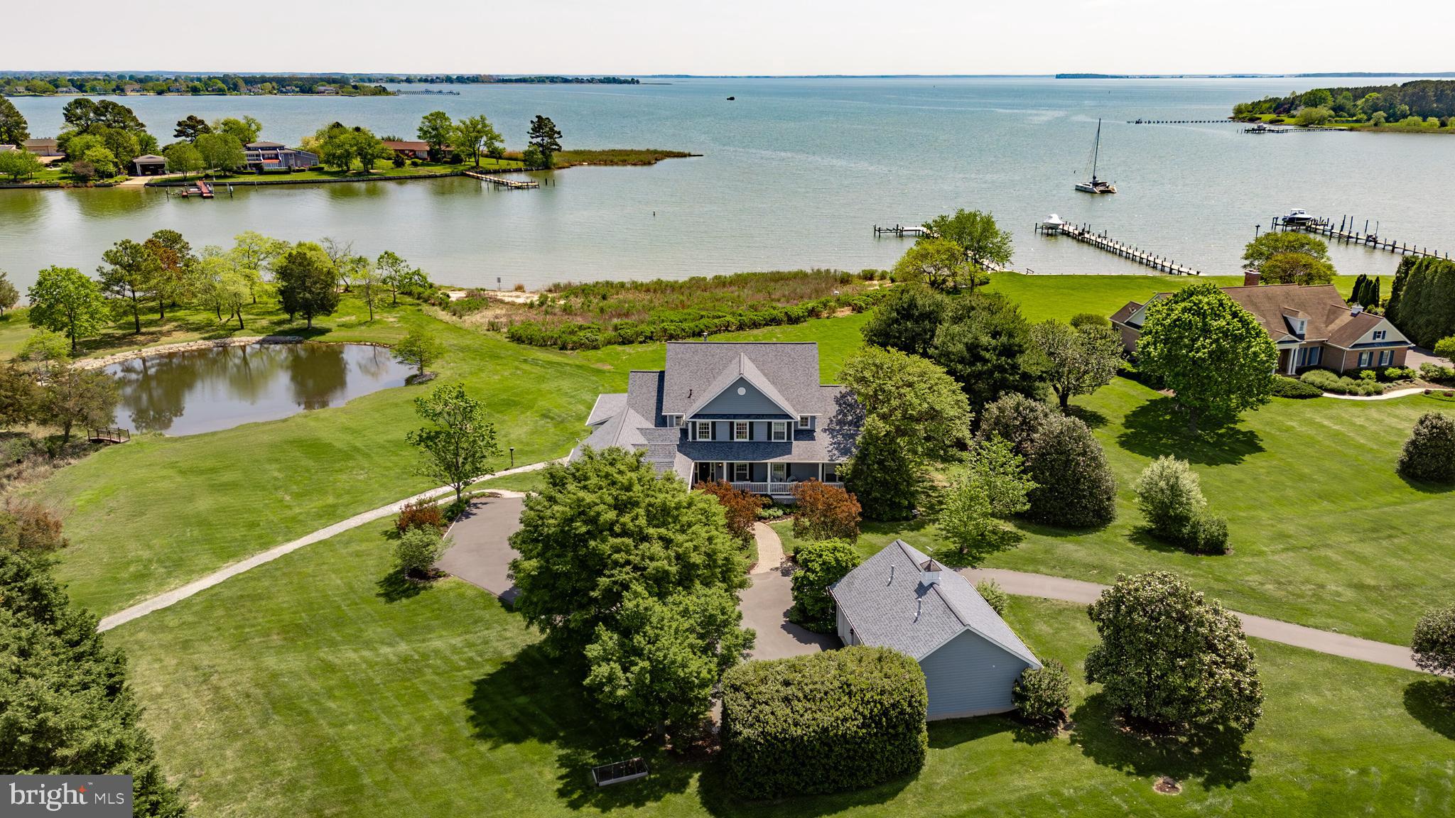 Discover the perfect blend of privacy, luxury, and natural beauty at this exceptional waterfront estate on the protected waterway of “Long Creek” with water views for eight miles across “Eastern Bay”. Situated on 3.42 acres with over 800 feet of rip raped shoreline.
Designed to capture breathtaking panoramic, water views from nearly every room, the home offers expansive living spaces ideal for both quiet relaxation and grand entertaining. The chef’s kitchen is outfitted with high-end appliances, granite countertops, and white cabinetry, flowing seamlessly into an enclosed sun porch and a covered outdoor porch. This home features five-bedrooms, three full baths, two half baths, and a desirable first-floor primary suite; all bedrooms have water views.
Enjoy the best of outdoor living with a private 100 foot pier with a 12,000 pound boat lift and a second 2,000 lb. jet ski / boat lift. There is also a sandy beach and tidal pond, all perfect for fishing, boating, kayaking or simply unwinding in nature.
Additional features include hardwood and tile flooring, corian surfaces, generous storage, and durable hardiplank siding, as well as a new two year old architectural shingle roof. This property also includes an attached finished three car garage and a detached finished and heated three-car garage for added storage and convenience.
Surrounded by beautifully designed gardens and mature trees, this one-of-a-kind waterfront retreat delivers spectacular sunrises, serenity and endless opportunities for recreation and entertainment.