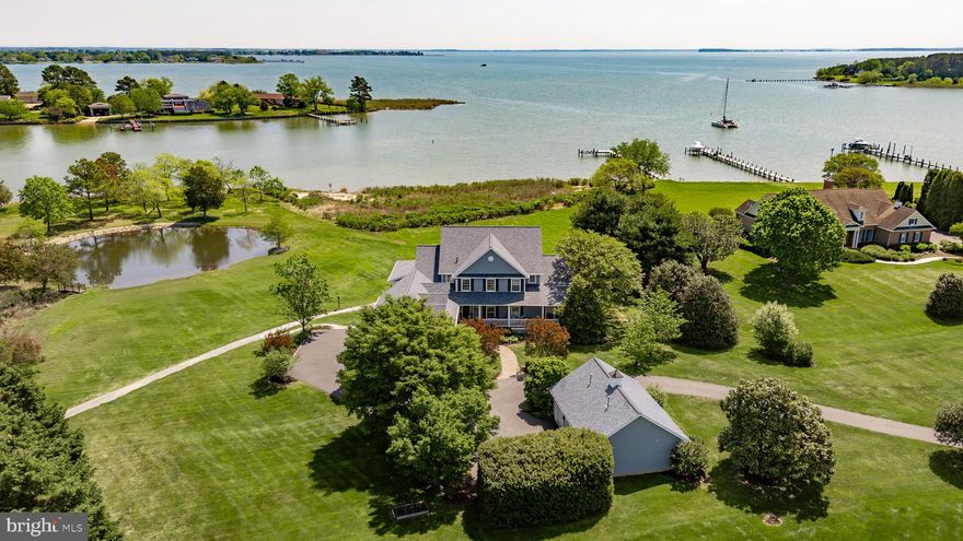 Discover the perfect blend of privacy, luxury, and natural beauty at this exceptional waterfront estate on the protected waterway of “Long Creek” with water views for eight miles across  “Eastern Bay”.  Situated on 3.42 acres with over 800 feet of rip raped shoreline. 

Designed to capture breathtaking panoramic, water views from nearly every room, the home offers expansive living spaces ideal for both quiet relaxation and grand entertaining. The chef’s kitchen is outfitted with high-end appliances, granite countertops, and white cabinetry, flowing seamlessly into an enclosed sun porch and a covered outdoor porch. This home features five-bedrooms, three full baths, two half baths, and a desirable first-floor primary suite; all bedrooms have water views.
Enjoy the best of outdoor living with a private 100 foot pier with a 12,000 pound boat lift and a second 2,000 lb.  jet ski / boat lift.  There is also a sandy beach and tidal pond, all perfect for fishing, boating, kayaking or simply unwinding in nature. 

Additional features include hardwood and tile flooring, corian surfaces, generous storage, and durable hardiplank siding, as well as a new two year old architectural shingle roof.  This property also includes an attached finished three car garage and a detached finished and heated three-car garage for added storage and convenience.

Surrounded by beautifully designed gardens and mature trees, this one-of-a-kind waterfront retreat delivers spectacular sunrises, serenity and endless opportunities for recreation and entertainment.
