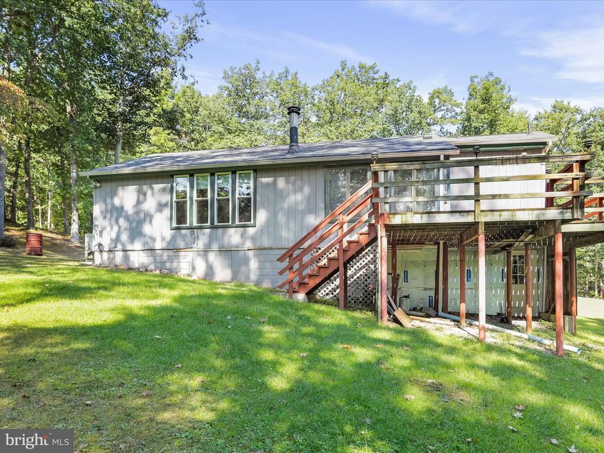 Charming and well-maintained ranch-style home situated on 4.84 private acres in Hedgesville. This 2-bedroom, 2-bath property offers a peaceful setting with recent updates throughout. 
The kitchen features luxury plank flooring and Formica countertops. Carpeted living room provides a cozy space for relaxation, while the dining/sunroom offers additional living space and leads to a rear deck—perfect for entertaining or enjoying the outdoors. 
Primary bedroom includes an attached full bath. Mini-split system provides efficient heating and cooling. Additional features include a new roof, newer windows, and a wood stove installed just one year ago. 
Ample outdoor space for gardening, recreation, or future expansion. Convenient to local amenities while offering privacy and tranquility. 
Don’t miss this opportunity—schedule your showing today!