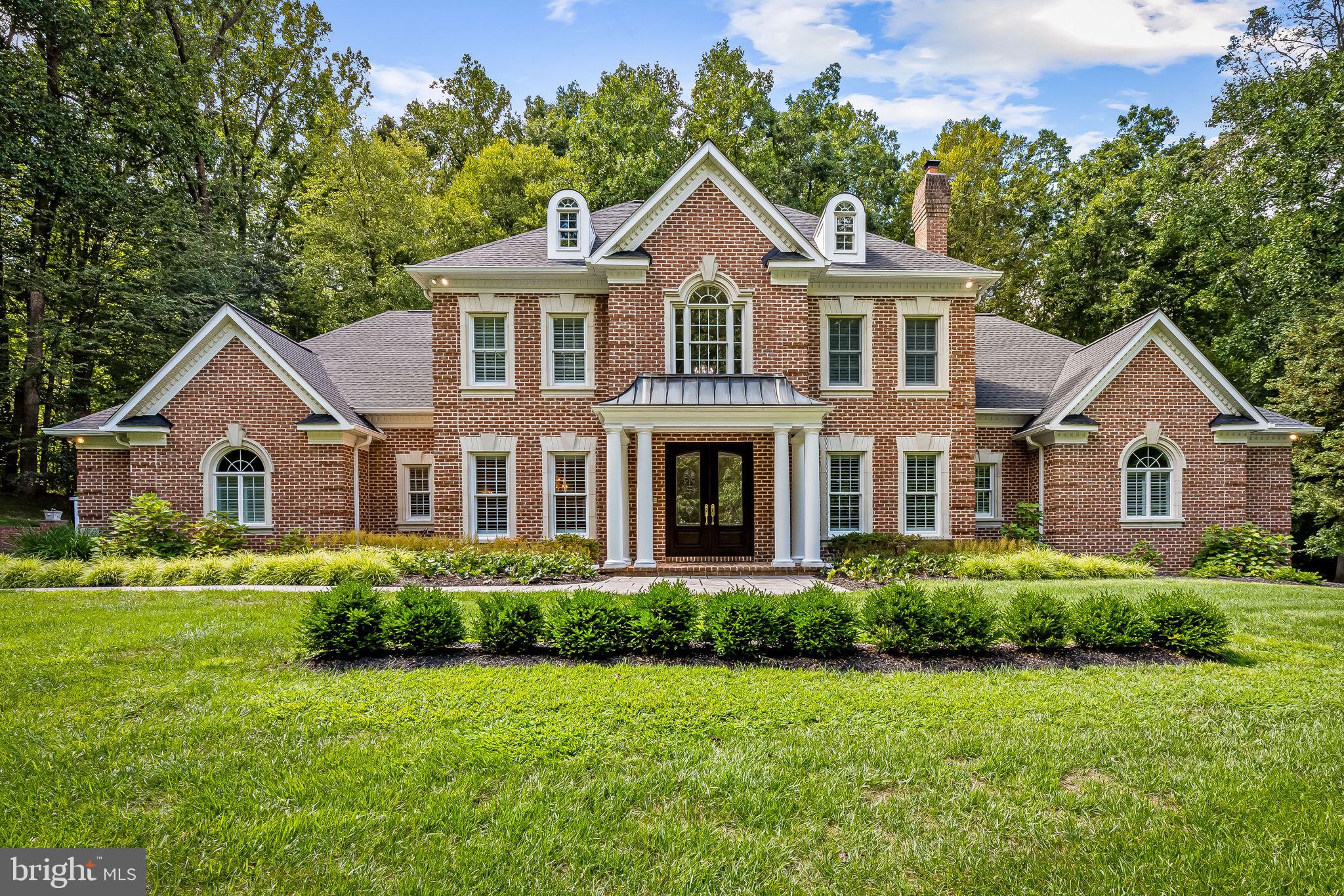Welcome to this timeless all-brick estate in the heart of Monkton’s coveted Hereford Zone, where classic elegance meets modern comfort. Surrounded by serene countryside yet close to everyday conveniences, this home offers both refined living and everyday practicality. Enjoy peace of mind with thoughtful updates, including a new architectural roof (2025), freshly serviced septic (2025), induction cooktop (2024), dishwasher (2023), dual-zone HVAC systems (2022), bluestone patio and walk (2022), paved driveway (2022), and water heater (2019). Step through stately mahogany doors into a grand foyer with a 20-foot ceiling and a Schonbek chandelier on a motorized lift. The home unfolds with Carlisle wide-plank, quarter sawn oak floors, ten-foot ceilings, seven-piece crown molding, and plantation shutters. To one side, a formal living room with a marble-surround wood-burning fireplace invites quiet conversation; to the other, a formal dining room is ready for intimate gatherings. The heart of the home is the soaring family room with a 15-foot vaulted ceiling and striking wood burning, bluestone fireplace, which flows seamlessly into the chef’s kitchen and breakfast area, featuring custom red birch cabinetry, granite counters, gourmet appliances, and a large center island with seating. A first-floor laundry room and a powder room add everyday convenience. The luxurious main-level primary suite is a true retreat, complete with a sitting area, two walk-in closets, and a spa-like bath. A versatile second bedroom on this level provides flexibility for guests or a home office. Upstairs, four spacious bedrooms with generous closets are served by two full baths and a half bath. One bedroom includes custom shelving, ideal for a study or playroom. Carlisle wide plank flooring prevails throughout the second floor with 9-foot ceilings. The walkout basement (2,000 sq. ft.) offers an entertainer’s paradise with a wet bar, theater area with 7.2 surround sound, gym space, and a full bath. With a full kitchen rough-in, second laundry, and 1,500 sq. ft. of storage, this level also provides excellent in-law or guest-suite potential. Outdoor living is a delight with a 3-car garage, a covered veranda, and a flat backyard with ample space for a future pool. All of this is set against 140 acres of protected Conservancy land, ensuring unmatched privacy. Located minutes from the NCR Trail, Gunpowder River, and Maryland’s horse country, and with easy access to I-83, this is more than a home; it’s a legacy of quality and a backdrop for a lifetime of cherished memories.