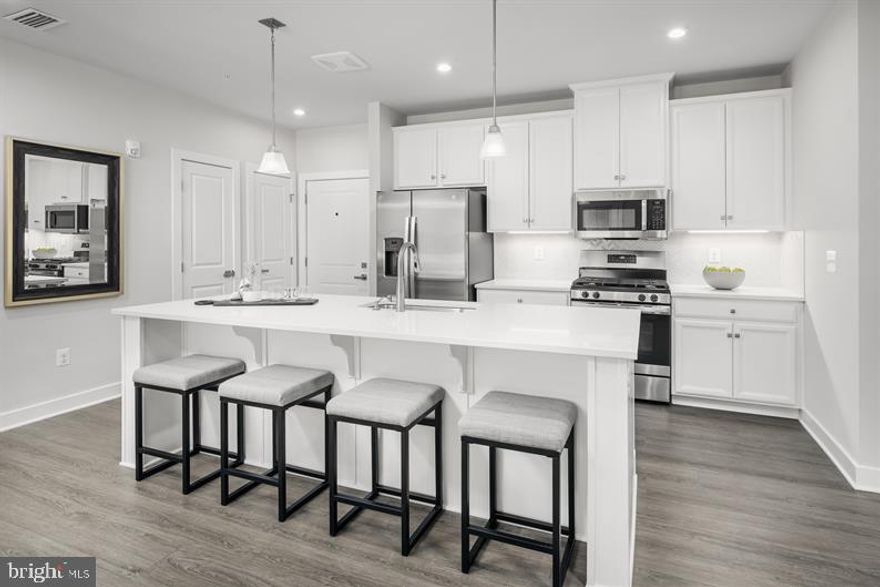 Luxury 55+ Condos at Liberty Place - a Ryan Homes community featuring 2-bedroom, 2-bathroom, elevator condos. This brand new condo features an open layout with luxury designs including a gourmet kitchen w/ quartz countertops and stainless-steel appliances, a spacious primary bedroom with ensuite spa bath and walk-in closet, a private outdoor patio, washer/dryer, wide plank flooring, custom lighting and much more. Liberty Place is a maintenance-free community located close to shopping and everyday conveniences. 2-2-2 Year Warranty included. Onsite Sales Representative available for appointments. Photos for representation only.