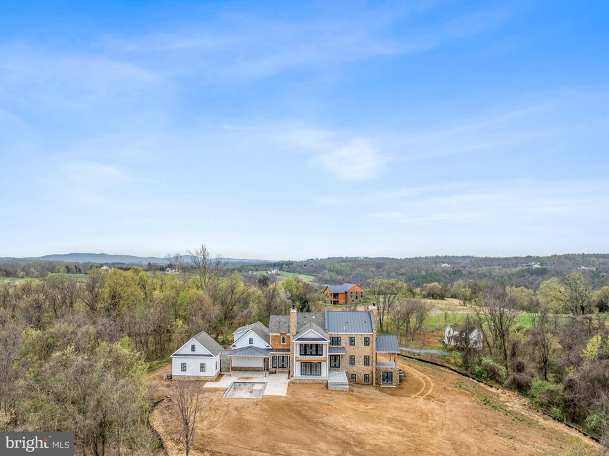 Knightsbridge Estates, a thoughtfully curated community in Loudoun County, is completing their first residence in Summer 2025.  Lot 27 is truly one-of-a-kind, featuring a stunning English-style elevation that perfectly blends the charm of the “new-old" design with the comfort and luxury of modern living on an elevated site spanning over 27 acres, providing breathtaking, unobstructed western views of the Blue Ridge Mountains.  The floorplan boasts 8,047 sq feet of finished living space on three levels with a convenient 1-bedroom in-law or au-pair suite over the 3-car garage. The residence has tasteful selections throughout including a Bertazzoni range, designer Subzero column freezer & refrigerator, Shaws of Darwin farmhouse sink, natural stone countertops & fireplace surrounds, paneled appliances, custom premium cabinetry, exquisite molding, Rohl plumping fixtures, Victoria & Albert freestanding soaking tub, Visual Comfort listing, and engineered European oak hardwood floors.  There is a separate c1800 farmhouse to the property that has been thoughtfully renovated with approximately 1,000 sq feet and serves as an ideal 1 bed/1.5 bath guest house.  This Loudoun County property has mature trees with outdoor living and entertaining spaces, a gunite swimming pool, detached 2-car garage, and room for horses.   Knightsbridge Estates is conveniently located less than 30 minutes from Dulles International Airport, 45 minutes from Washington DC, and within 15 minutes from downtown Leesburg and Middleburg.  The property offers a rare combination of serenity, seclusion, and proximity to amenities.  Madison Dale collaborated with Purple Cherry Architects in the design.  No HOA.  Verizon Fios is available.  The Lot 26 guest house is now open to the public every Wednesday from 3-5 pm for buyers to view the quality & aesthetic of finishes and tour the house and lots available. Detailed spec package available upon request.