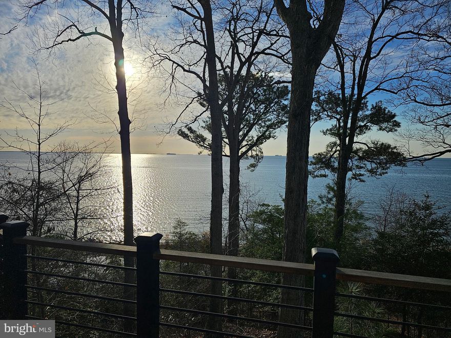 Welcome to a rare offering on the Chesapeake Bay—this architect-designed 1979 Acorn Deck House seamlessly blends timeless mid-century modern design with breathtaking waterfront living. Privately tucked among the trees, this exceptional split entrance home showcases signature post-and-beam construction, rich natural wood finishes, and dramatic walls of glass that frame panoramic bay views from both levels and almost every room.  

Step inside to a light-filled main level where soaring cathedral ceilings and floor-to-ceiling windows create a stunning connection to the water. Family room features a wood burning brick fireplace and flows effortlessly into the updated kitchen and dining area complete with Corian countertops, center island, and heated floors—perfect for gathering and entertaining. A sunroom and expansive wraparound deck extend your living space outdoors, offering front-row seats to ever-changing Chesapeake Bay vistas.

The primary suite is a true retreat, featuring private deck access, sweeping water views, and a beautifully updated bath with jetted tub, walk-in shower, and heated ceramic tile floors. A renovated guest half bath completes the main level.

The lower level is equally impressive, filled with natural light and designed for both relaxation and functionality. Enjoy a spacious rec room with a second brick fireplace, direct access to the lower-level deck, two additional bedrooms, a fully renovated bath, and generous storage areas.

Outside, a private walkway leads to your own sandy beach along the Chesapeake Bay—an incredible extension of this already remarkable property. A two-car garage with direct access to the home adds convenience to this one-of-a-kind property. 
This is more than a home—it’s a lifestyle defined by architecture, privacy, and unparalleled waterfront views.