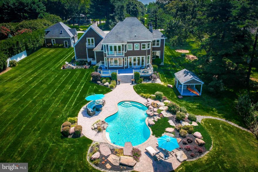 Welcome to your private waterfront oasis at  2512 Bennett Point Rd.  From the moment you enter the property the quality of construction and attention to detail is apparent and the wide open sunset views of Greenwood Creek will take your breath away! This  home was custom built in 2009 sparing no expense on landscaping, materials and workmanship and was designed with year round entertainment in mind.  A fabulous home for the car enthusiast with parking for 3 in the main residence and 3 additional stalls in the separate garage with over 1500 sf of unfinished space above, perfect for any home business. No HOA  rules or fees. Outstanding construction details including double insulation throughout, 2 x 6 framing,  top of the line Anderson windows, underground drainage system, lawn irrigation system, new board and batten Certain Teed Landmark vinyl cedar shake siding and the entire property is landscaped with lava and river rock for mulch free gardening. The heated in-ground pool features two stunning rock waterfalls & dive board and the 210' lighted pier offers swim platform,  two lifts (12K and 14K), two 30 amp hookups and can easily accommodate 5-6 boats for your summer gatherings. The patterned white rock rip rap ends at your own private beach complete with fresh sand! Decorative fencing, fish pond with waterfall, pool house and playground are included.  The interior has been masterfully constructed featuring an open floor plan with large comfortable rooms, 10' ceilings, 2.5" wide plank oak hardwood flooring throughout, Electrolux central vacuum, custom built-in cabinetry in the Great Room, main level Game Room or Home Office and gourmet French County Kitchen with rich wood cabinetry, tiled flooring, Wolfe cooktop, stainless appliances, oversized pantry, reverse osmosis water system and all rooms with fabulous views of the water.  Just outside you will enjoy nightly sunsets from the oversized low-maintenance composite deck with clear view of pool, pier and water's edge.  The second level features large Master Suite with tray ceiling, large Master Bath with separate sinks and jetted tub, his/her walk in closets & Deck overlooking the water,  upper level laundry, 2 additional Bedrooms each with full Bath and a large Bonus Room/4th BR above garage.  This 4300+ SF home and separate detached garage is beautifully situated on a level 1.25 acre lot and was designed for efficient living and the easy maintenance -free lifestyle you are looking for! Bennett Pt. Rd is near the Queenstown Golf Course and Shopping Center,  between Annapolis and Easton and less than an hour to BWI Airport.