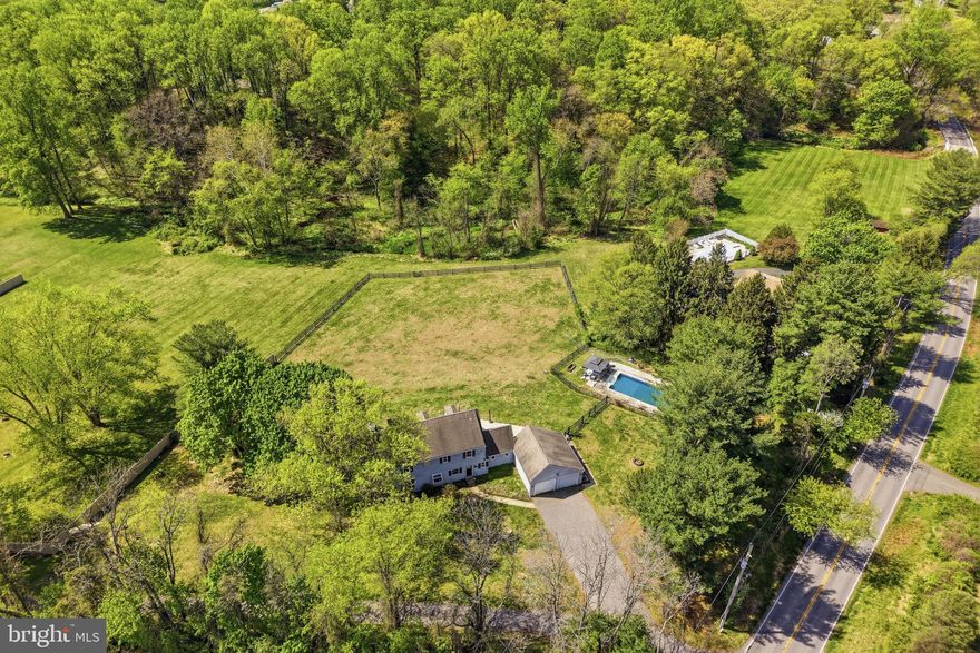 Imagine ending every day with a soft breeze, open land, and a golden sunset- this is what nearly 3 private acres in one of the area's most sought-after locations actually feels like. Minutes from Fair Hill Nature Center, a short drive to Newark's Main Street and the University of Delaware, and an easy shot into Pennsylvania, the setting is rare. But it's the property itself that will stop you in your tracks. Outside, an 18x34 in-ground pool anchors a partially fenced backyard wrapped in mature trees, with a fire pit area, and patio that were made for summer evenings. Inside, the updated main level delivers a cozy country kitchen- granite counters, white cabinets, subway tile backsplash, new plank flooring, and stainless appliances- that flows into a open space eating area and family room with a wood stove and two glass sliders framing stunning rolling hill views. A mud room with vaulted ceilings, wood beams, and custom cabinetry connects to the two-car garage, plus a flexible bonus room works perfectly as a 4th bedroom or home office. Upstairs, the owners suite is anchored by a brick fireplace and barn-style closet doors, with a spa bath featuring a custom tile shower, dual vanity, and soaking tub with brass accents. Two additional bedrooms and a sun-filled loft area- ideal as a reading nook or creative space- round out the upper level. Head down to the basement and you'll find a finished rec room with new carpet and fresh paint, ready to use from day one. A separate unfinished section houses the HVAC and offers serious storage space- the kind that actually keeps the rest of the home clutter-free. Peaceful retreat and entertainer's dream, finally in one place.