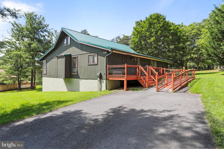 Opportunity on the Green – 3BR Golf Course Home in The Woods
239 The Woods Road, Hedgesville WV 25427

This 3-bedroom, 2-bath golf course home offers over 1,900 square feet of flexible living space with a view across from the #1 green of the Mountain View Course. Built in 1990, this early Chestnut model sits on a block foundation with a metal roof (installed in 2017) and an expansive back deck perfect for entertaining, relaxing, or soaking in the wooded surroundings.

Highlights include:
• Open-concept kitchen/dining area with vaulted ceiling, kitchen island (conveys), and newer appliances (excluding range/hood)
• Large back deck with multiple zones for lounging, dining, and a concrete pad ready for a hot tub
• Woodstove in the great room with brick surround and thermal piping for added warmth and character
• Natural wood accents on the staircase wall and exposed beams add a rustic touch
• Three bedrooms, each with ceiling fans and generous light; guest bath updated with new sink, lighting, mirror, and wall storage
• Primary suite features vaulted ceiling, private full bath with walk-in shower, double sink vanity, ceramic tile flooring, and linen closet
• Dedicated laundry room with storage space
• Loft area adds bonus square footage—perfect as an office or flex space

This property is handicap accessible, with a ramped entry and a thoughtfully updated primary bathroom. The crawlspace below the home is impressive in both size and function, featuring a full vapor barrier, two 50-gallon water heaters, sealed block foundation (Sta-Dry), and added joists for extra support.

Please note: This home does not currently include a Woods Club membership, but buyers may inquire about adding either a Class A or Class B membership (one-time initiation fee of $3,150 applies).

With solid infrastructure, strong bones, and a golf course location, this home presents a compelling opportunity for a buyer ready to bring their own vision and finishing touches to life. Whether as a full-time residence or weekend retreat, there’s room here to create something special in a vibrant mountain community.
