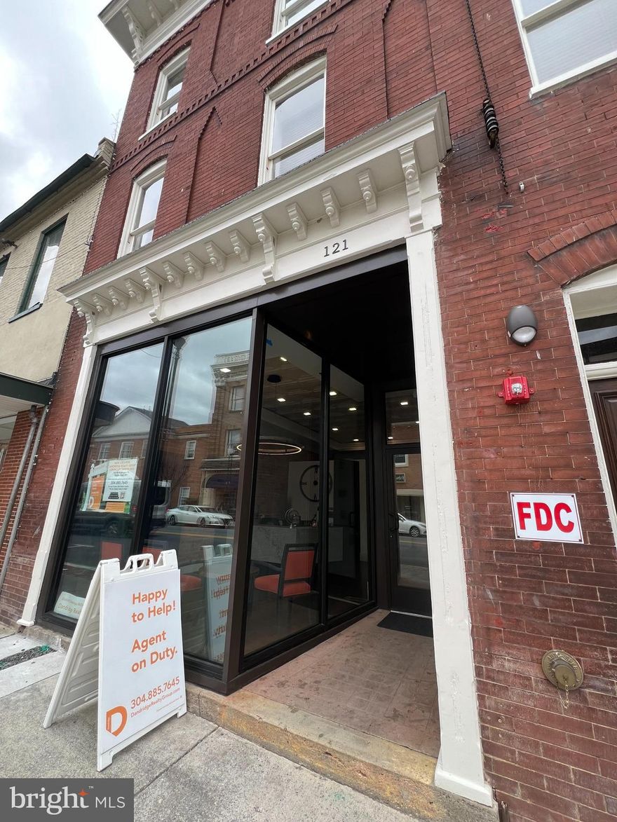 This is a brand new renovation of a historic property in downtown Charles Town, WV. The rent includes one 95 sq foot private office with locking door in a busy office environment. Rent includes a private office, use of a full-time receptionist (8:30-4:30), conference room, training room, several lounge areas, and a shared kitchen. All utilities including dedicated fiber wifi also included. The office is located is a busy downtown business district with 2 coffee shops and several restaurants in addition to shops and the post office, all within walking distance. Rate includes utilities, building services and property expenses. Amenities include: Fully Built-Out as Professional Services Office Fits 1 - 2 People 2 Conference Rooms Finished Ceilings: 8’ - 9’ Space is in Excellent Condition Plug & Play Central Air and Heating Reception Area Wi-Fi Connectivity Fully Carpeted Drop Ceilings Shower Facilities