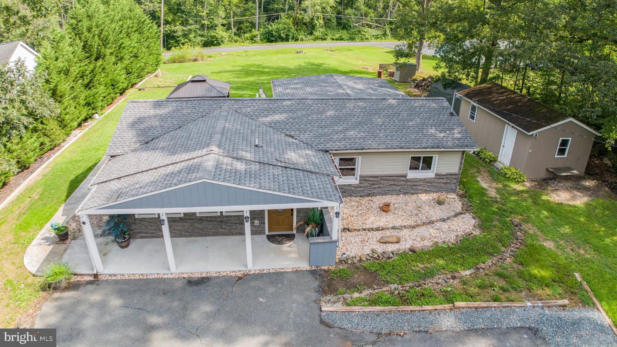 Welcome to this 2 bed, 2 full bath modern true rancher on .62 acres of cleared private land. This house has been completely remodeled and updated. Entering in brings you to the main level with lvp flooring throughout. A living room area is to the right and to the left is the kitchen. The large kitchen comes with all stainless appliances, plenty of counter space and custom cabinetry throughout. Off of the kitchen is an open concept dining area which looks out over the living room and a short hallway to the rear sliders. Off of this hallway is a large walk in pantry/storage room. The rear sliders lead out to the deck that overlooks the large cleared rear yard. (The gazebo and patio furniture can stay with house.). Back in the main living room, a hallway leads to a full bath with walk in shower and a bedroom. On the other side of this hallway is a large owners suite with vanity area and walk in closet, as well as a private en-suite bathroom. This bathroom is modern and updated with a quartz vanity and tiled shower with built in speakers and a night light. This house has been done with quality workmanship and all the details have been covered. There is also a parking pad and large shed in the yard, and the front of the home has had a facelift including the covered concrete front porch that spans the front of the home. The roof is only 3 years old, the Trane Hvac system is only 3 years old, the electric has been upgraded and has two panels, and all new gutters have been added t the home. This is peaceful, easy living in a home with no maintenance needed for some time!