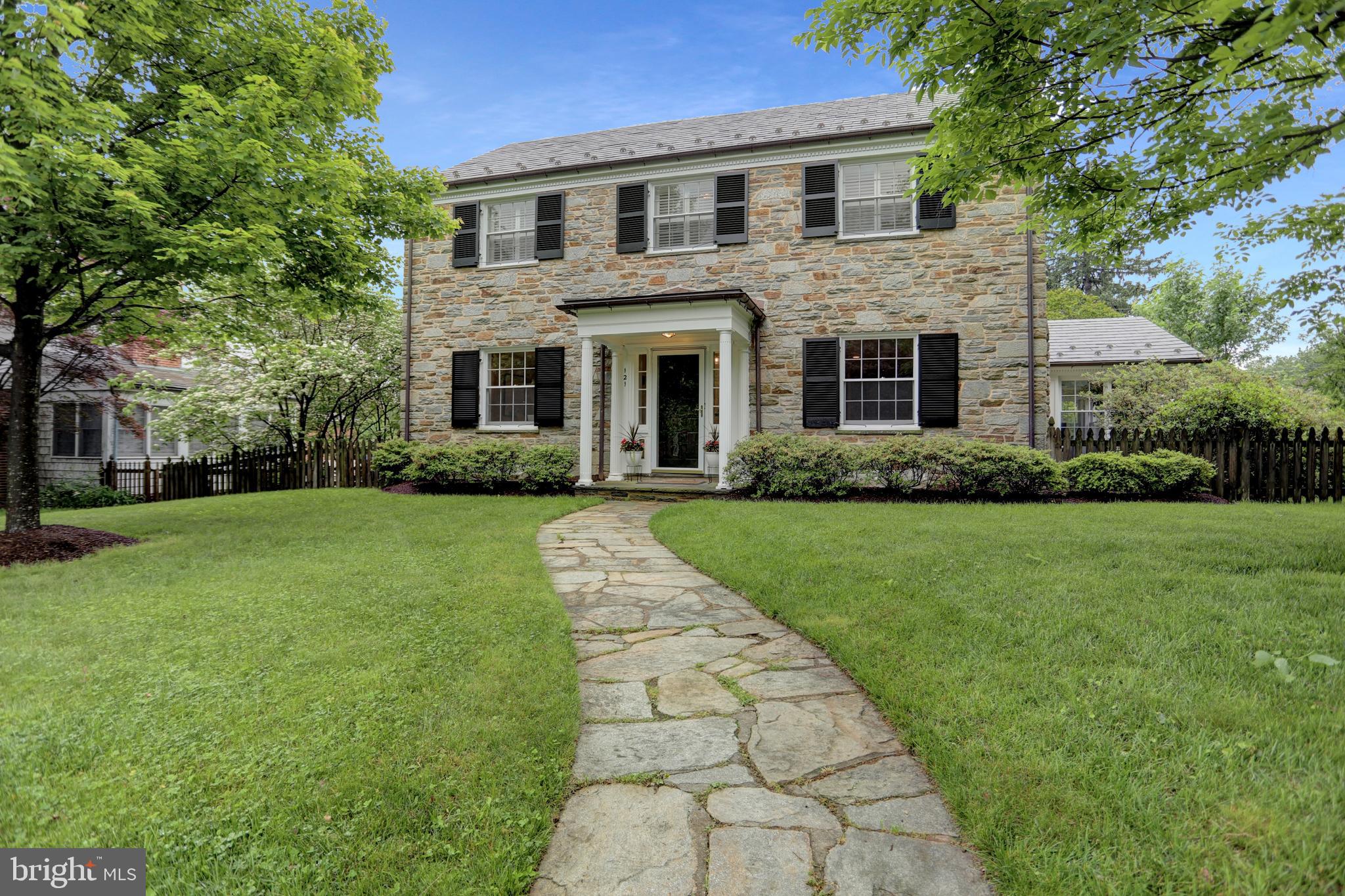 Nestled in the heart of Baltimore’s coveted Homeland neighborhood, this pristine 1950s stone colonial is a rare architectural gem that blends timeless charm with thoughtful updates and unbeatable walkability. Recent major updates include a slate roof, copper gutters, shutters (2022), and most windows have been restored, and chimneys relined. Every detail has been carefully curated for lasting beauty and function.
Step along the stone walkway to discover a home renovated with utmost care. The formal living room features a wood-burning fireplace flanked by double built-in bookcases, while the elegant dining room is accented by chair rail molding and a stylish light fixture. The kitchen is bright and sunny, designed with custom cabinetry and countertops, stainless steel appliances, an island, and a cozy dining or sitting area.
Upstairs, the expansive primary suite offers a luxurious private bath, complemented by three additional bedrooms and a second full bath. Throughout the home, gorgeous hardwood floors, recessed lighting, and plantation shutters speak to the quality and care throughout. The finished lower level includes new luxury vinyl plank flooring, a welcoming family room, a laundry area, and a half bath, and an extra storage area.
Outside, entertain or relax on the beautiful stone patio with a seating wall, overlooking the level, fenced backyard—perfect for grilling, games of croquet, a bocce match, lacrosse practice, or simply enjoying a quiet afternoon. The property also includes an attached two-car garage and private rear driveway access.
Beyond the home, Homeland offers an unmatched lifestyle—enjoy historic walking paths, nearby fine and casual dining, the Enoch Pratt Library, and proximity to premier private and public schools, universities, world-class hospitals, and major league sports venues. It's just a short stroll to the iconic ‘Spring Lakes’—ideal for feeding ducks, admiring blooming trees, or spotting a heron.
Perfectly located for commutes uptown, downtown, or even to Washington, DC, with easy access to Penn Station. Your patience has paid off—the wait is over. There is no place like Homeland!