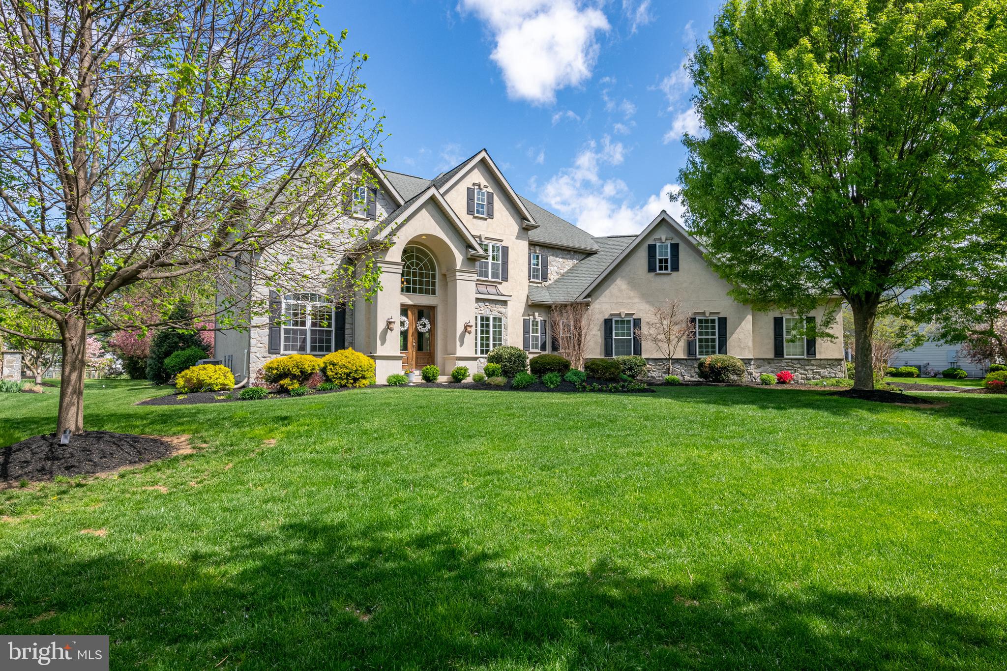 Built in 2006 by Costello Builders, this extraordinary residence on a .76-acre lot is located in the Stonehenge community of Manheim Township. With unique style, the home is based on the original owner’s plans, resulting in a one-of-a-kind property adorned with high-end lighting fixtures and premium quality floor coverings. The exterior showcases stucco and stone, while inside, you’ll find soaring ten-foot ceilings on the main level and nine-foot ceilings on the second floor. Rich crown molding runs throughout the home. The layout offers five bedrooms and four full bathrooms, including a guest suite and attached bath on the main level, ideal for family or visiting friends. As you enter this stunning home through the double doors, you’re welcomed into a dramatic two-story foyer with a graceful, curved staircase and HomerWood solid hickory hardwood flooring. The main level boasts a formal dining room with tray ceiling, an expansive great room with a coffered ceiling and oversized fireplace, and a hearth room adjacent to the kitchen with a stone fireplace—a cozy spot for TV or relaxation. The heart of the home is the Manny Beiler kitchen with a large seating island, breakfast room, and two sliding doors leading to the patio. Just off the kitchen and great room is a wet bar with filtered water. Entering from the garage is a mudroom outfitted with 18-inch tile flooring, a custom workstation, built-in cubbies, spacious pantry, coat closet, and stylish half bath. Completing the main level is a private office that can also serve as a bedroom. A second staircase gives convenient access to the second floor. Upstairs, the large primary suite features a wall of windows overlooking the serene backyard. You’ll love the luxurious primary bath with stone tile flooring, dual custom vanities, a jetted soaking tub, and a glass-enclosed stone tile shower. A generously sized walk-in closet leads directly into the laundry room. With built-in cabinets, a sink, and a built-in ironing board, this well-equipped laundry space also has access from the hallway. Three additional bedrooms are on this level, one with a private bath and two that share a Jack and Jill bathroom. The finished lower level is designed for entertaining and relaxation, complete with a custom-built wet bar and media center, high-end carpeting, and hand scraped hardwood flooring. Also in the lower level is a billiards/game room, an exercise room with a glass viewing window and door, and a flexible bonus room that can be used as a bedroom or adapted to suit your needs. Outside, the property is surrounded by beautiful landscaping and provides a covered patio perfect for outdoor gatherings. An uncovered patio extension includes a built-in grill, a stone woodburning fireplace, Techo-Bloc flooring, and a seating wall, creating space for entertaining year-round. Additional amenities include a three-car garage, a central vacuum system, and hookup for a whole house generator. This gorgeous home blends comfort, craftsmanship, and elegance with everything you need for modern luxury living. Schedule your private tour today.