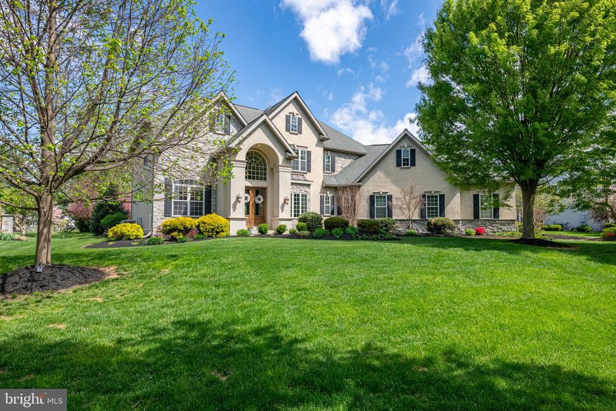 Built in 2006 by Costello Builders, this extraordinary residence on a .76-acre lot is located in the Stonehenge community of Manheim Township. With unique style, the home is based on the original owner’s plans, resulting in a one-of-a-kind property adorned with high-end lighting fixtures and premium quality floor coverings. The exterior showcases stucco and stone, while inside, you’ll find soaring ten-foot ceilings on the main level and nine-foot ceilings on the second floor. Rich crown molding runs throughout the home. The layout offers five bedrooms and four full bathrooms, including a guest suite and attached bath on the main level, ideal for family or visiting friends. As you enter this stunning home through the double doors, you’re welcomed into a dramatic two-story foyer with a graceful, curved staircase and HomerWood solid hickory hardwood flooring. The main level boasts a formal dining room with tray ceiling, an expansive great room with a coffered ceiling and oversized fireplace, and a hearth room adjacent to the kitchen with a stone fireplace—a cozy spot for TV or relaxation. The heart of the home is the Manny Beiler kitchen with a large seating island, breakfast room, and two sliding doors leading to the patio. Just off the kitchen and great room is a wet bar with filtered water. Entering from the garage is a mudroom outfitted with 18-inch tile flooring, a custom workstation, built-in cubbies, spacious pantry, coat closet, and stylish half bath. Completing the main level is a private office that can also serve as a bedroom. A second staircase gives convenient access to the second floor. Upstairs, the large primary suite features a wall of windows overlooking the serene backyard. You’ll love the luxurious primary bath with stone tile flooring, dual custom vanities, a jetted soaking tub, and a glass-enclosed stone tile shower. A generously sized walk-in closet leads directly into the laundry room. With built-in cabinets, a sink, and a built-in ironing board, this well-equipped laundry space also has access from the hallway. Three additional bedrooms are on this level, one with a private bath and two that share a Jack and Jill bathroom. The finished lower level is designed for entertaining and relaxation, complete with a custom-built wet bar and media center, high-end carpeting, and hand scraped hardwood flooring. Also in the lower level is a billiards/game room, an exercise room with a glass viewing window and door, and a flexible bonus room that can be used as a bedroom or adapted to suit your needs. Outside, the property is surrounded by beautiful landscaping and provides a covered patio perfect for outdoor gatherings. An uncovered patio extension includes a built-in grill, a stone woodburning fireplace, Techo-Bloc flooring, and a seating wall, creating space for entertaining year-round. Additional amenities include a three-car garage, a central vacuum system, and hookup for a whole house generator. This gorgeous home blends comfort, craftsmanship, and elegance with everything you need for modern luxury living. Schedule your private tour today.