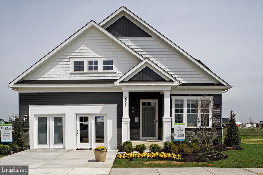 This stunning model home is now for sale! Located walking distance to the extensive community amenities, this great home backs to a pond and delivers a sought after open floorplan with upgraded and designer appointments throughout.
The main level home designs featuring 10' ceilings keeps your lifestyle needs at the forefront. Upon entering the foyer, a private study is accessible.  Head to the large kitchen which in itself is a dream with gourmet stainless steel appliances, quartz countertops, navy cabinets and a farmhouse style sink.  The kitchen opens to the family room which offers a cozy gas fireplace. Step out into the rear screened in porch or even onto the finished paver patio which has great views of the pond! 
The main level primary suite features two large walk-in closets and deluxe bathroom with a walk in shower, quartz counters and upgraded cabinets.  Two secondary bedrooms, a full bath, and laundry room  with front loading washer and dryer are also on the main level.
The upper level features a large loft, additional secondary bedroom and private bath — extending your living space even further.
Head down to the walk out basement for even more entertainment space including a large recreation room highlighted by an exposed brick wall, and media room, an additional bedroom with large walk-in closet, and full bath.
Additionally, this home has oak stairs throughout, laminate plank flooring on the main level, upgraded and custom trim throughout, professional landscaping and so much more! Available for early 2023 move in!! Closing cost assistance is available. 
Experience something different here at Two Rivers 55+. Located in Odenton, Maryland; Every day will be a vacation at Two Rivers with amazing amenities like walking trails, indoor and outdoor pools, golf courses and so much more. Plus, it's all so close to everything you already know and love.