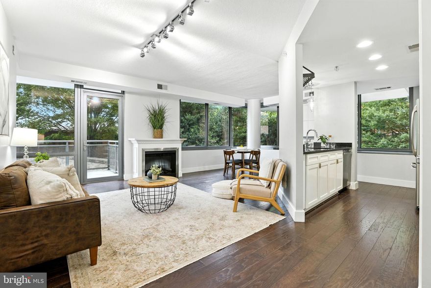 Welcome home to The Odyssey, the premier address for upscale living in one of Arlington’s most coveted neighborhoods! Elevated above the heart of Arlington Courthouse, this luxury, full-service condominium offers an exquisite corner residence that blends contemporary architecture with refined finishes and a flawless open floorplan. From the moment you enter, you’ll be welcomed by elegant hardwood flooring and the expansive wall-to-wall windows that flood the space with natural light while still offering serene privacy thanks to the lush tree canopy that surrounds this rare corner unit. The renovated kitchen is a true designer showpiece, boasting stainless steel appliances, sleek granite countertops, and a peninsula breakfast bar with stylish pendant lighting. This modern elegant space flows directly into the spacious dining and living rooms, anchored by a cozy gas fireplace - making the home ideal for everyday life or effortless entertaining. Down the hall, each bedroom is a private retreat, featuring a generously-sized walk-in closet with a custom organization system and a spa-inspired en suite bathroom complete with a frameless glass door shower and wide modern vanity. Additional highlights include convenient in-unit laundry, a wide private balcony, and access to an unparalleled array of desirable amenities. Residents of The Odyssey enjoy a rooftop pool and terrace with panoramic monument views, a sauna and fully equipped fitness center overlooking the Potomac River and Georgetown skyline, an elegant party lounge with kitchen, 24/7 concierge service, and reserved parking in a secure garage. All of this just minutes to Whole Foods, Safeway, Target, Tupelo Honey Southern Kitchen, Bayou Bakery, Ballston Quarter, The Crossing Clarendon, AMC Cinemas, Arlington Courthouse, Reagan National Airport, Amazon HQ2, and The Pentagon. Less than one mile to the Clarendon and Courthouse Metro Stations, with quick access to Clarendon Boulevard, Wilson Boulevard, Fairfax Drive, Arlington Boulevard, I-66, GW Parkway, and I-395 for easy commuting and traveling around the DC area. Schedule a private tour of your stunning new home and elevate your lifestyle today!