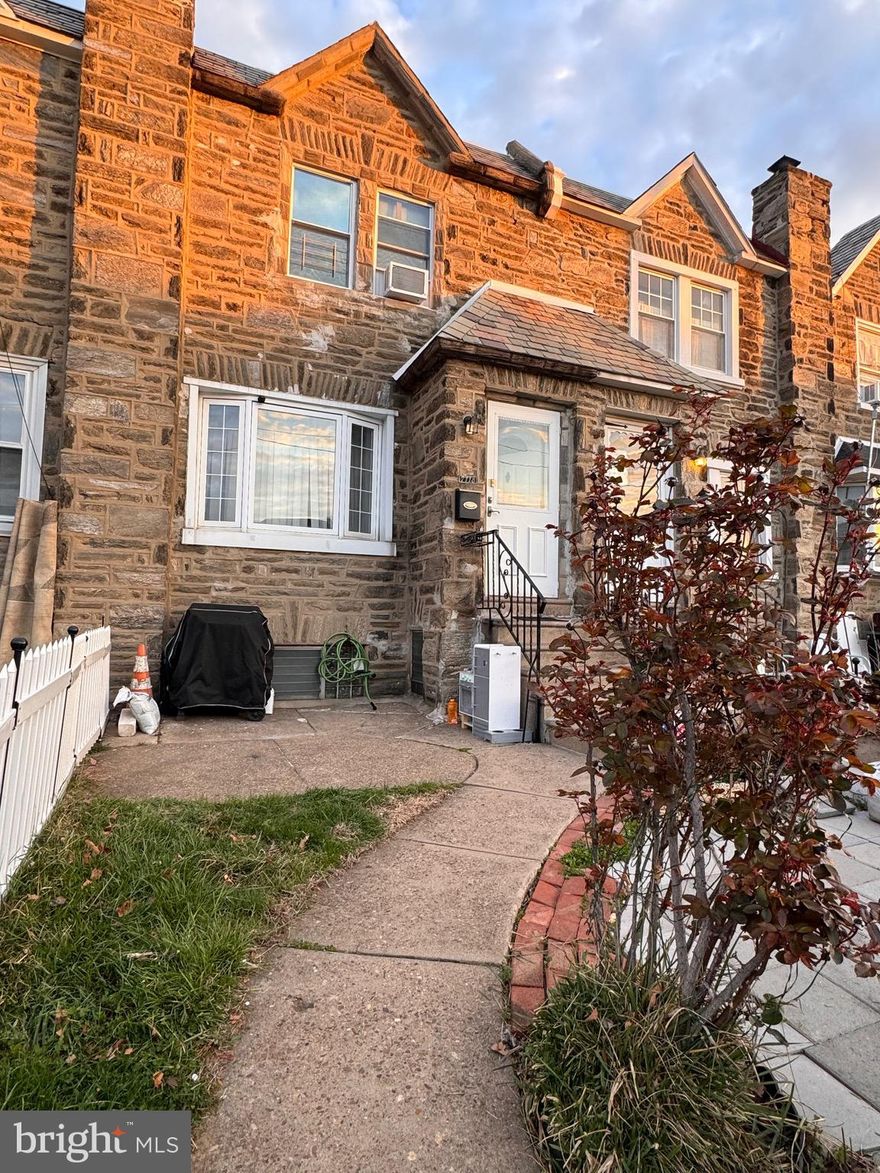 Welcome to this charming 3-bedroom, 2-bathroom stone-front, straight-through home located in the desirable Mayfair section of Northeast Philadelphia. This property boasts a lovely front yard and spacious front patio. Step through the foyer, lead to a large living room through a French-style door. The oversized bay window with a wide sill allows for an abundance of natural light to fill the space. The living room features recessed lighting and custom inlaid hardwood floors, adding a touch of elegance.
The kitchen is generously sized with an eat-in area, offering plenty of room for a large table.  The kitchen also provides access to the basement, where you'll find a spacious, finished area with tile flooring and recessed lighting. There's a hookup for a bar sink, as well as an additional full bathroom with a stall shower. The back room area includes a washer and dryer, along with access to the rear driveway. Additionally, there’s a convenient entrance to a one-car attached garage, perfect for extra storage or parking. The second floor features three well-sized bedrooms, all with wonderful details that flow throughout the home. Don’t miss the opportunity to make this property your own!