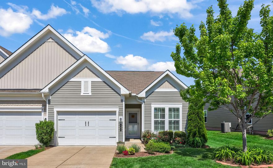 Welcome to this beautiful end-unit villa, which offers abundant natural light and a peaceful setting that the homeowners have truly appreciated. Located in the amenity-filled, 55+ Celebrate VA community, this 1600+ square foot home features one-level living with two bedrooms plus a versatile flex room, ideal for a tv room, home office, or more. The open floor plan seamlessly connects the kitchen, dining, and living room, which is highlighted by a cozy fireplace—perfect for both everyday living and entertaining.  The upgraded kitchen boasts a large center island, a modern backsplash, and plenty of workspace. A rear bump-out creates a bright sunroom-style area, adding extra living space and charm. Engineered hardwood floors and plantation shutters throughout enhance both style and comfort. Step outside to enjoy the private backyard and back deck complete with an awning—perfect for relaxing or entertaining outdoors. Additional features include a new A/C unit in 2025, a spacious one-car garage and a separate laundry room. This home combines low-maintenance living with thoughtful upgrades in a quiet, desirable setting that backs to trees and farmland.  Celebrate VA amenities, including the 30,000+ square foot Riverside Lodge Clubhouse with an indoor pool and spa, walking track, fitness center, billiards area, a ballroom with a kitchen, and more. The lovely grounds boast an outdoor pool, tennis and pickle ball courts, bocce court, large patio with gas grills, and an amphitheater. Call for your tour today and come join the Celebrate VA lifestyle!
