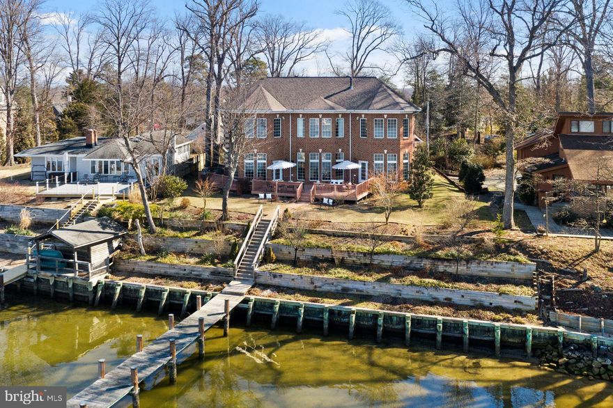 You will love this gorgeous custom designed 6428 square foot waterfront home overlooking the Rhode River on close to an acre. 4132 Cadle Creek is a boater's delight with a deep water dock and is only 5 minutes to Chesapeake Bay! Western exposure for serene and breathtaking sunsets from nearly every room. The open floor plan is designed for entertaining with one beautiful room flowing into another. Floor to ceiling windows fill the home with natural light and maximize the glorious views.  2 story high living room with fabulous custom cherry built-ins, double sided gas fireplace, one of a kind hand forged wrought iron railings and a dining room with architect designed ceiling soffits. Cooking is a treat in this great chef's custom kitchen with a breakfast bar and room for a big table. Kitchen features Decore microwave and wall oven, all stainless steel appliances, Wolf 6 burner stove, Thermador refrigerator, granite counters. Some of the many extras include a home generator, gas fireplace in master bedroom, state of the art theatre room with video /audio equipment and comfortable theatre seating for 6. Two owner suites including one on the main level. Finishes and appointments with imported marble and hardwood floors throughout the living areas, Christal chandeliers in foyer and dining room, custom designed solid cherry kitchen and built in cabinetry and marble mosaic inlay in the entry. No flood insurance required!