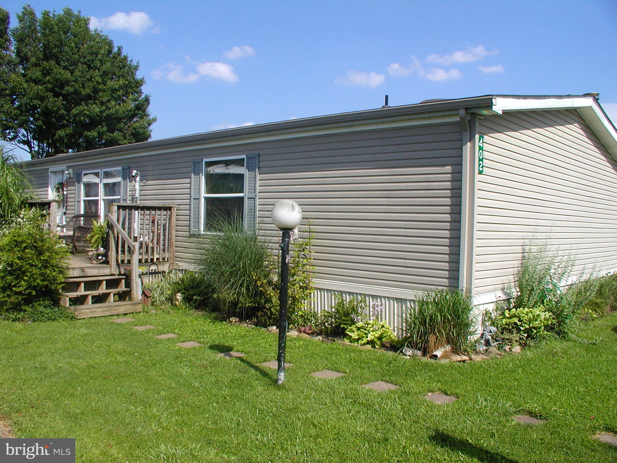 This beautifully kept 3-bedroom, 2-bathroom manufactured home offers 1,512 square feet of comfortable, functional living space with thoughtful touches throughout.
Step inside to a bright, open layout featuring laminate flooring and two cozy living areas. The family room is anchored by a wood-burning fireplace with a hook-up available for a gas insert, offering warmth and flexibility. The separate living room is made extra inviting with a pellet stove, perfect for relaxing evenings.
The owner’s suite is complete with a large walk-in closet and a spacious en-suite bath featuring a garden tub, separate shower, and skylight that fills the room with natural light.
Two additional bedrooms and a full hall bath provide plenty of space for family, guests, or a home office. Outside, enjoy a large parking pad, storage shed, and low-maintenance yard — all in a well-maintained setting. Park approval is required.