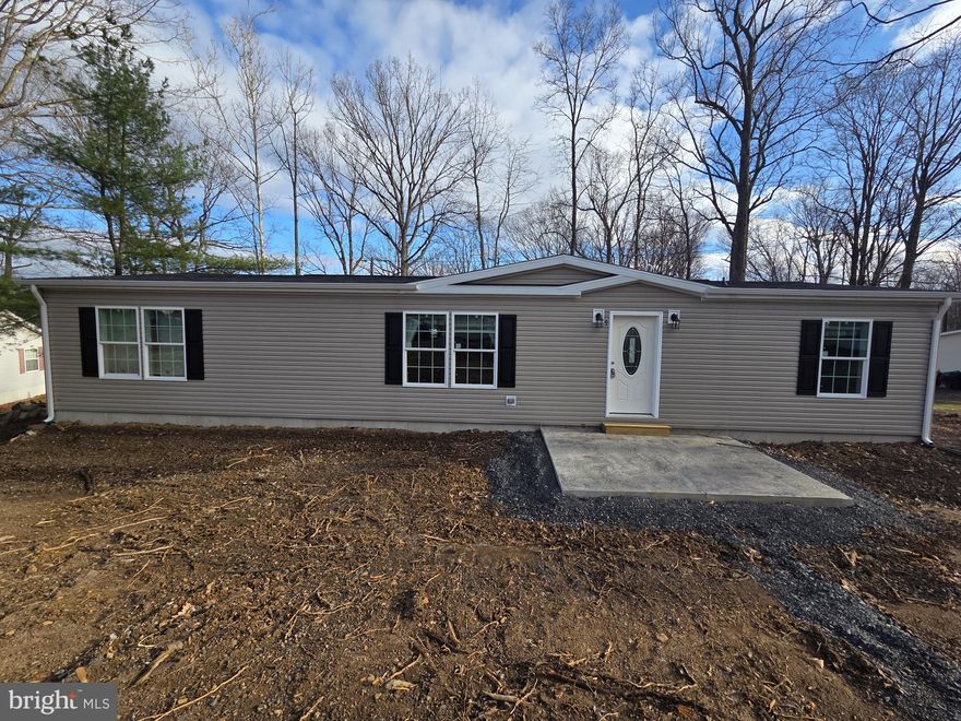 New 3 bed 2 bath home with front deck.  Open living area and kitchen with a large island, stainless steel farm sink, dishwasher, microwave, refrigerator and range with hood.   The primary bedroom has a nice sized closet and a full bath with walk-in shower.  Two more bedrooms, a hall bath and a laundry room complete this great home.  The home comes with central air, an 8’ x 8’ shed and a 1 year manufacturer warranty.  The $ 991 monthly land lease includes 1500 gallons of water/sewer use, the pool, mini golf, chip and putt, fishing ponds and use of the community pool for private functions. Park approval required.